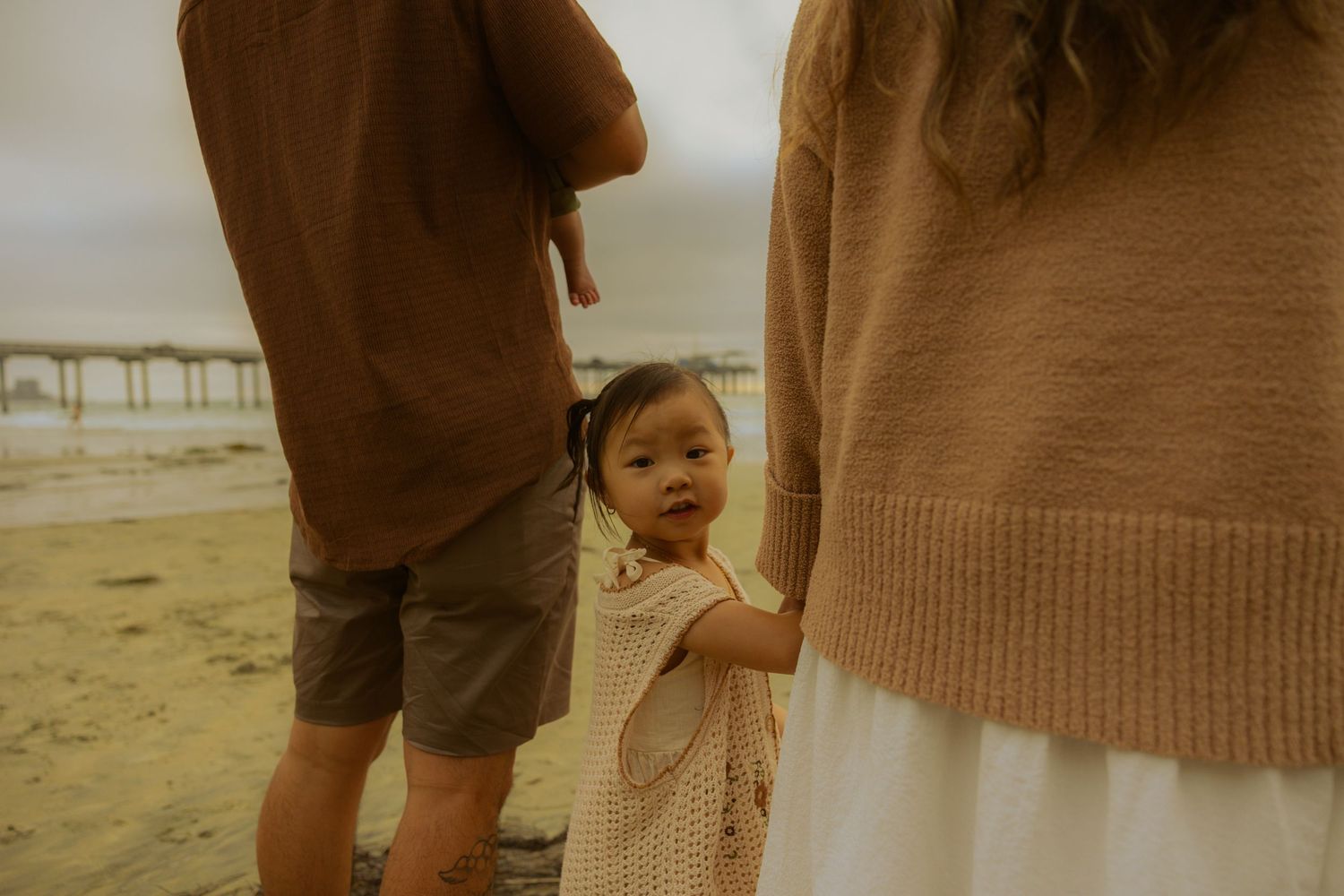 A photo album with a split collage of photos featuring family moments at a beach during golden hour lighting.
