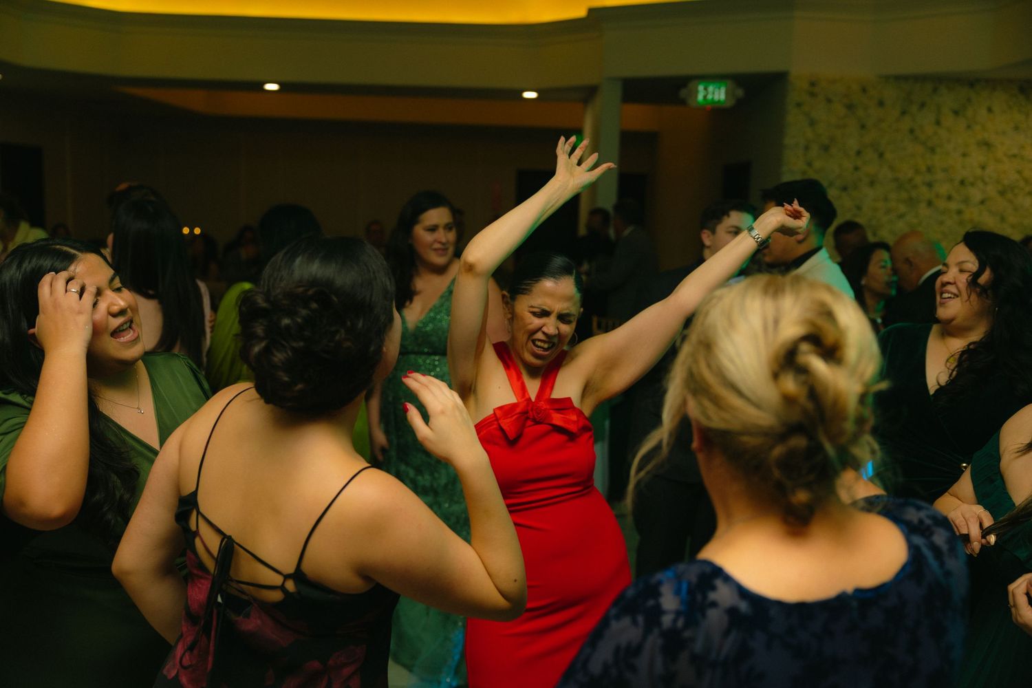 People dancing and having fun at a lively party with colorful lighting and energetic atmosphere.