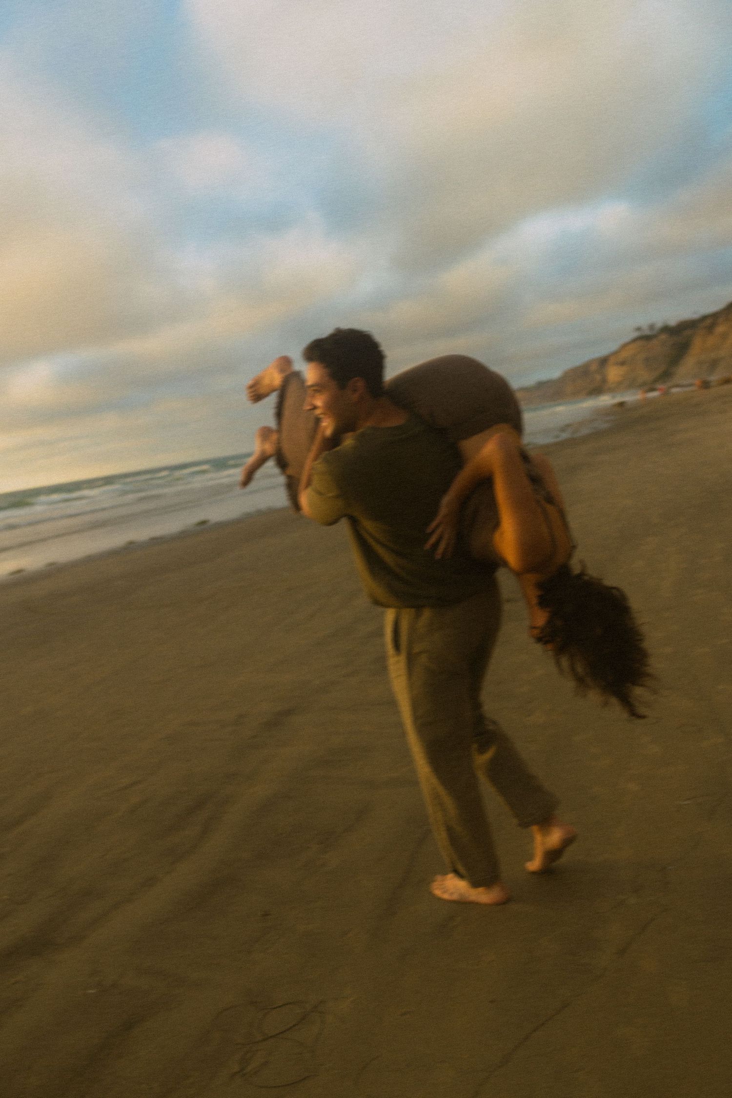 A sequence of photos showing a person taking pictures while bending backwards on a sandy beach at sunset.
