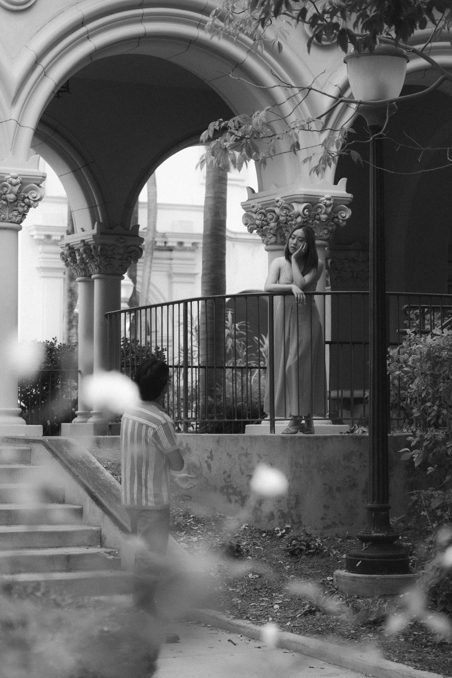 A sequence of black and white images showing a blurred figure walking through an arched colonnade with garden spaces.