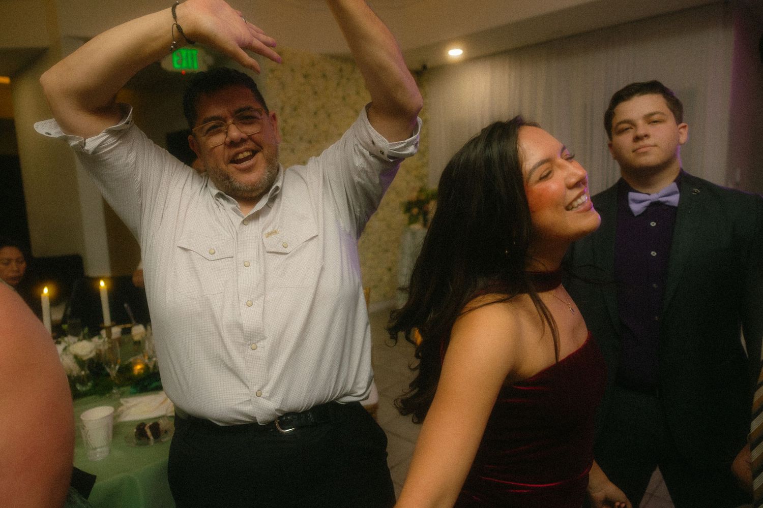 Party guests enjoying themselves with energetic dancing and celebration at a wedding reception.