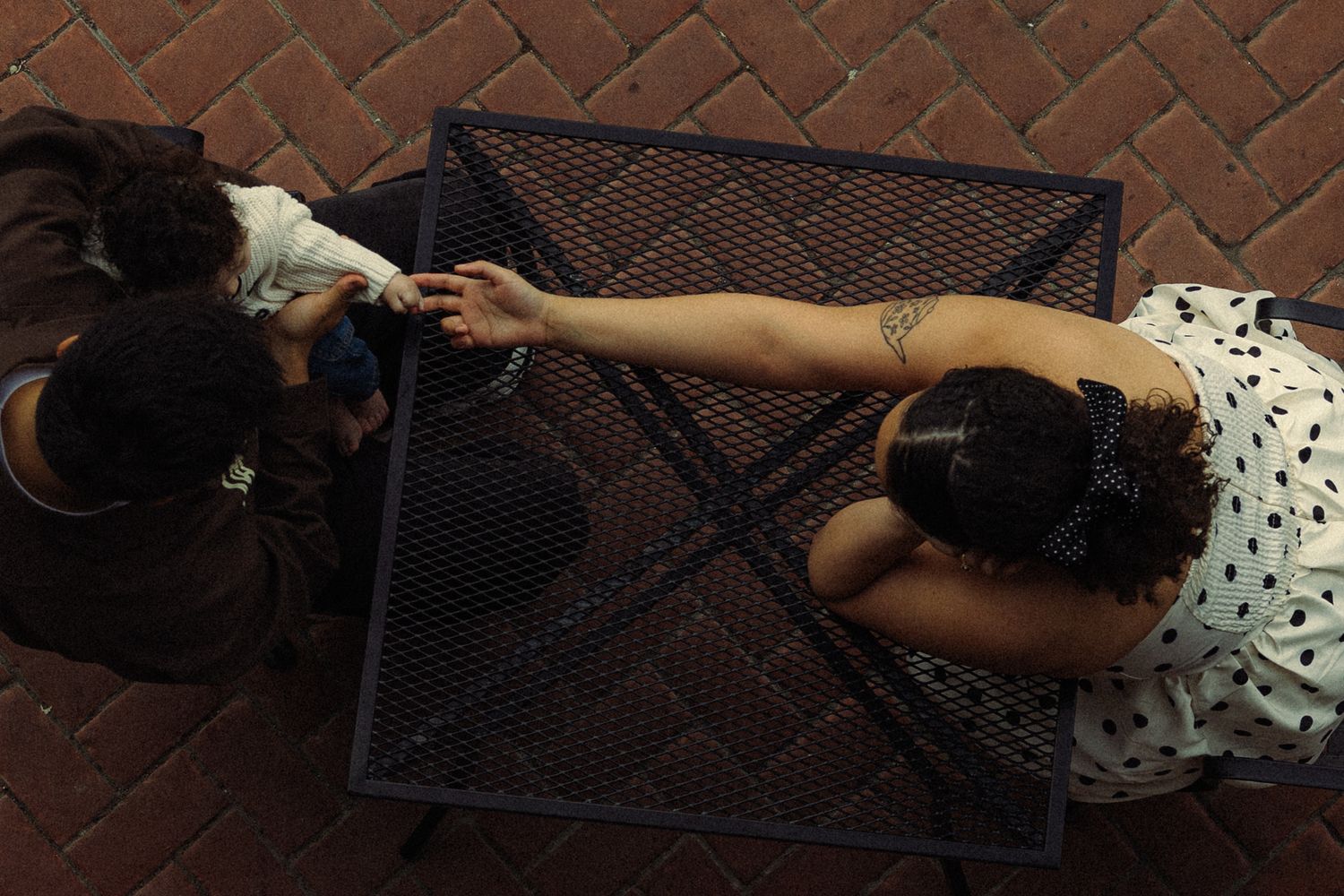 Person lying on a metal bench demonstrates a creative sequence of rolling movements in an urban setting.
