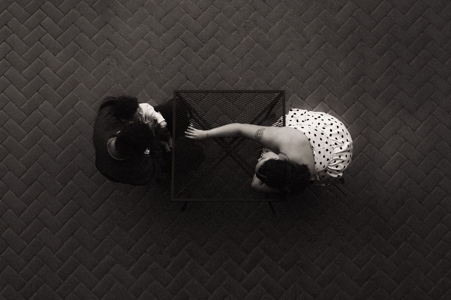 A series of black and white photos showing a person lying on a textured floor in different dramatic poses.