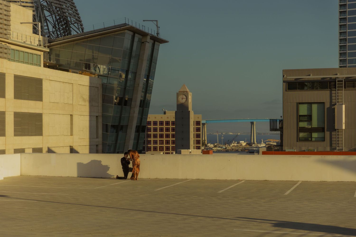 Panoramic view of a modern building exterior with glass windows and concrete architecture under blue sky.