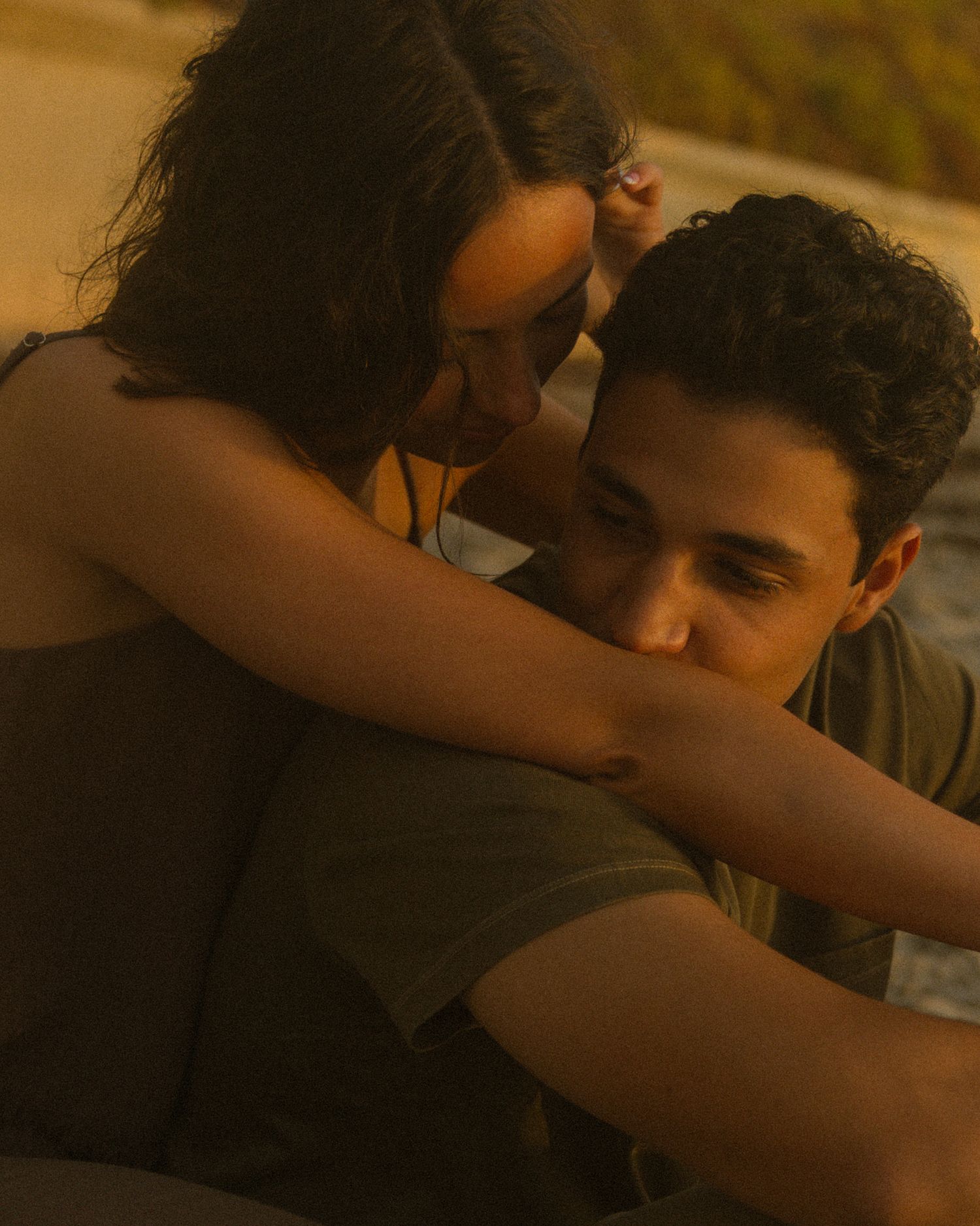A couple embraces intimately in warm lighting during a romantic moment together.