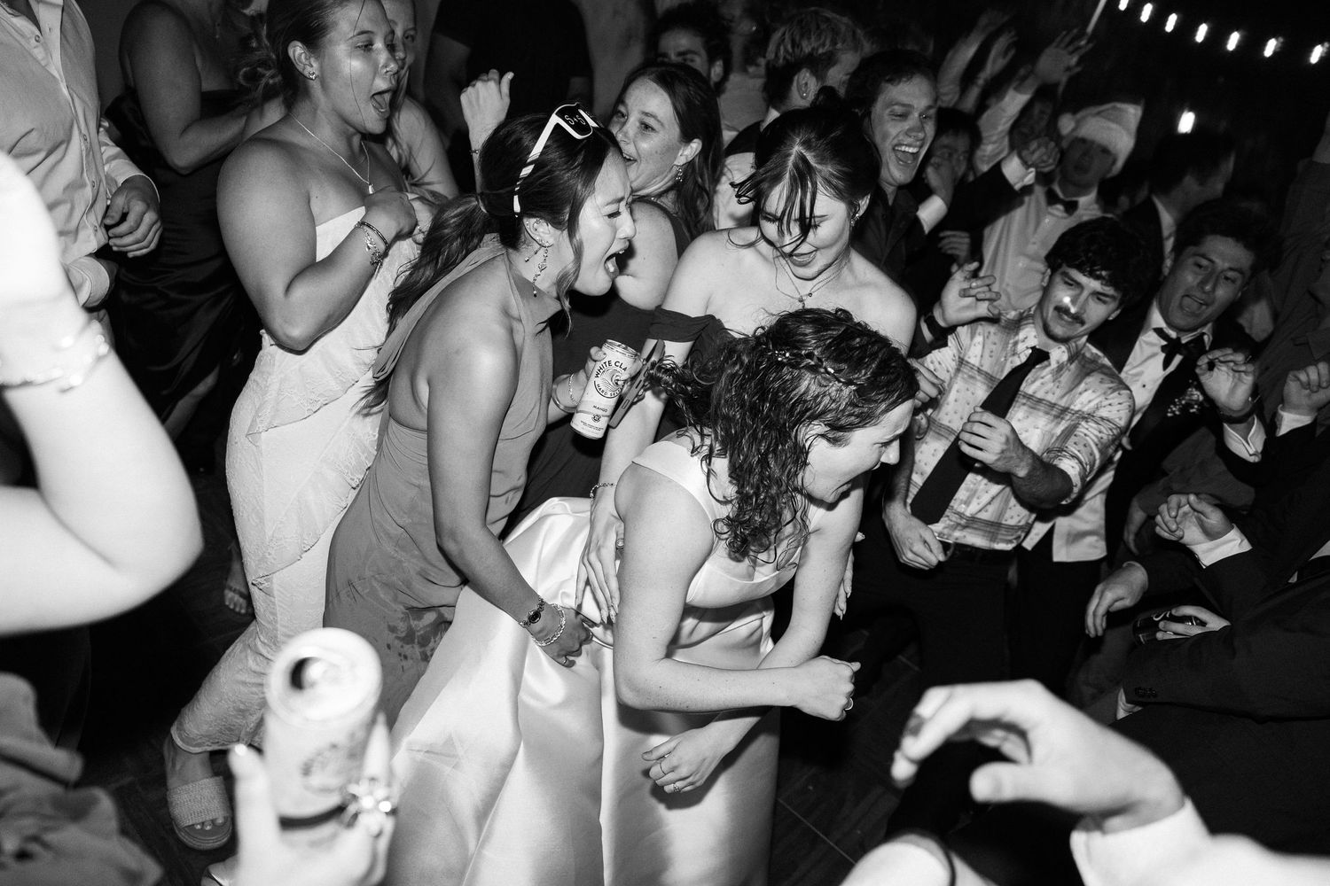 Guests dance and celebrate joyfully at a lively wedding reception party.