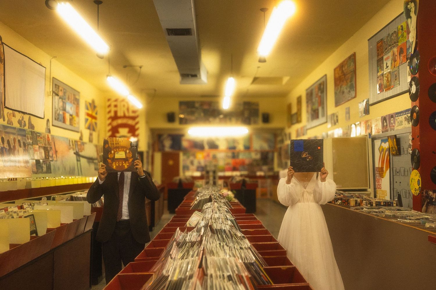 A long hallway in a bowling alley with vintage decor and glowing fluorescent lights overhead.