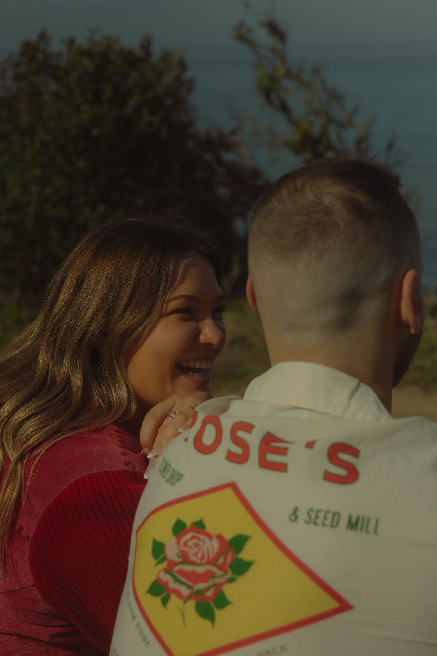 A joyful moment shared between two people wearing casual attire outdoors.