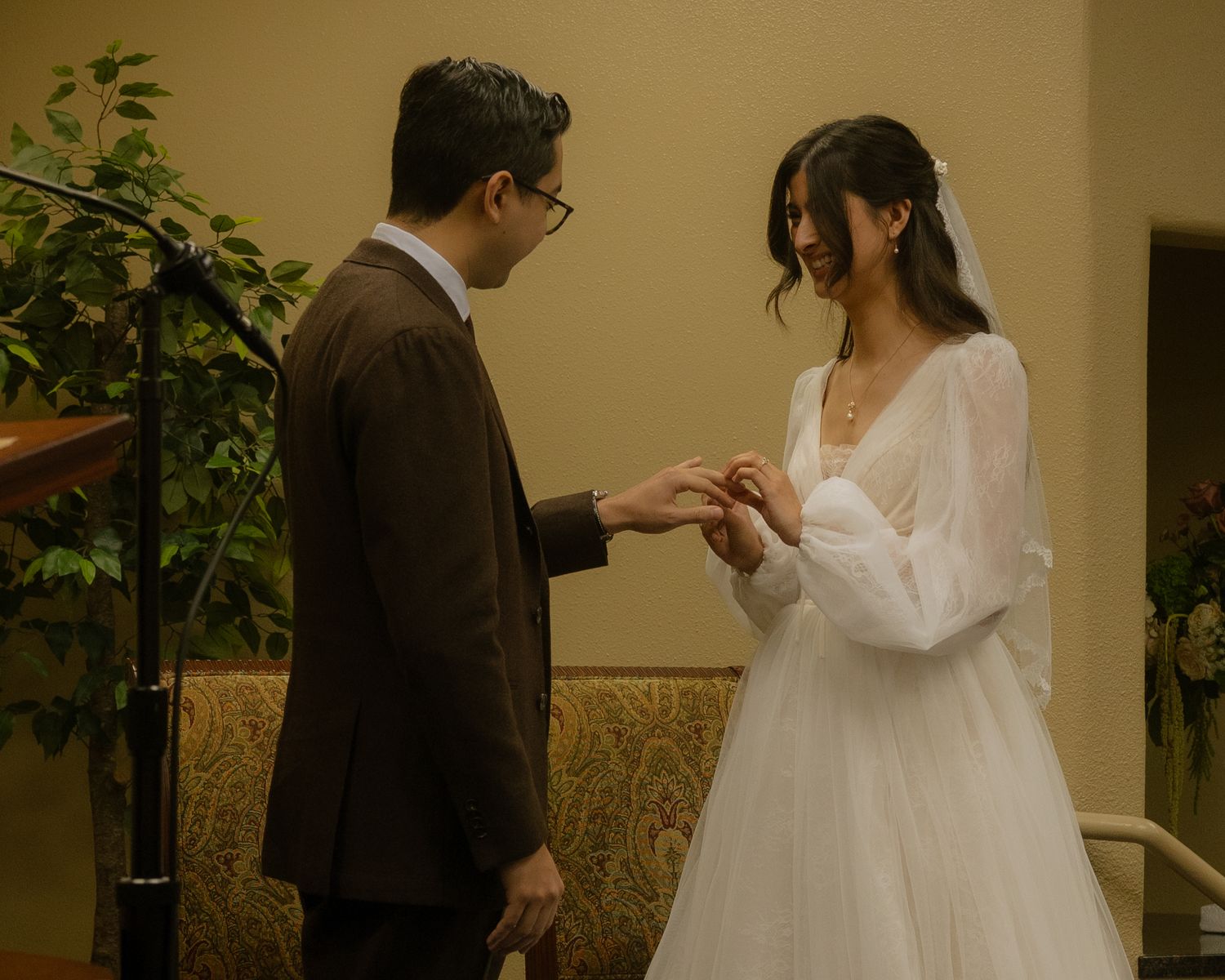 A couple dances together in an elegant ballroom setting during their wedding celebration.