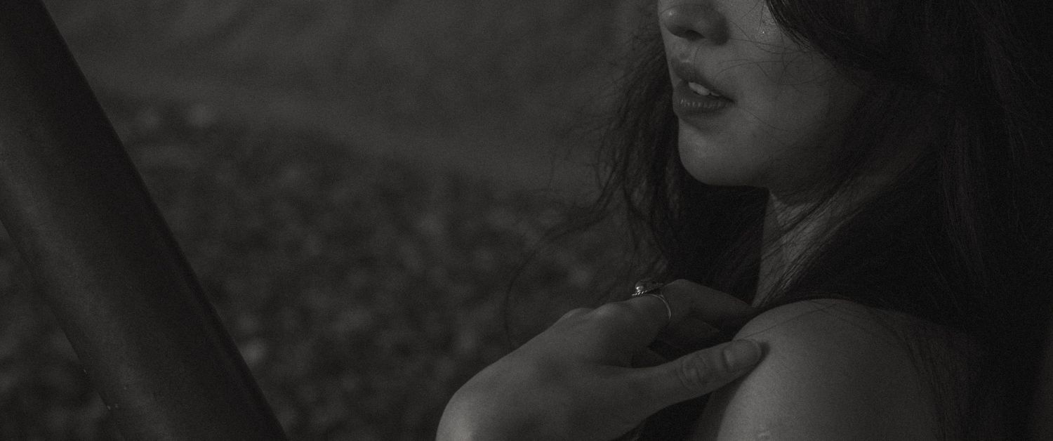 An intimate black and white close-up portrait with dramatic shadows and lighting.
