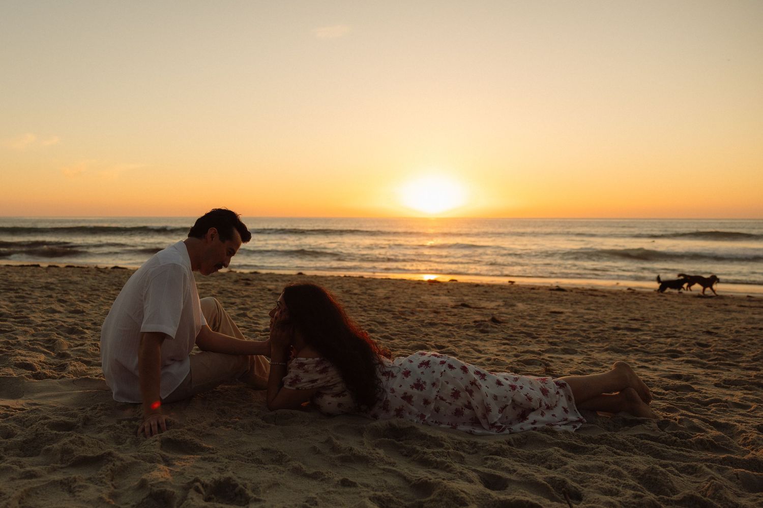 A serene beach scene at sunset with golden light reflecting off the ocean waves and sand.