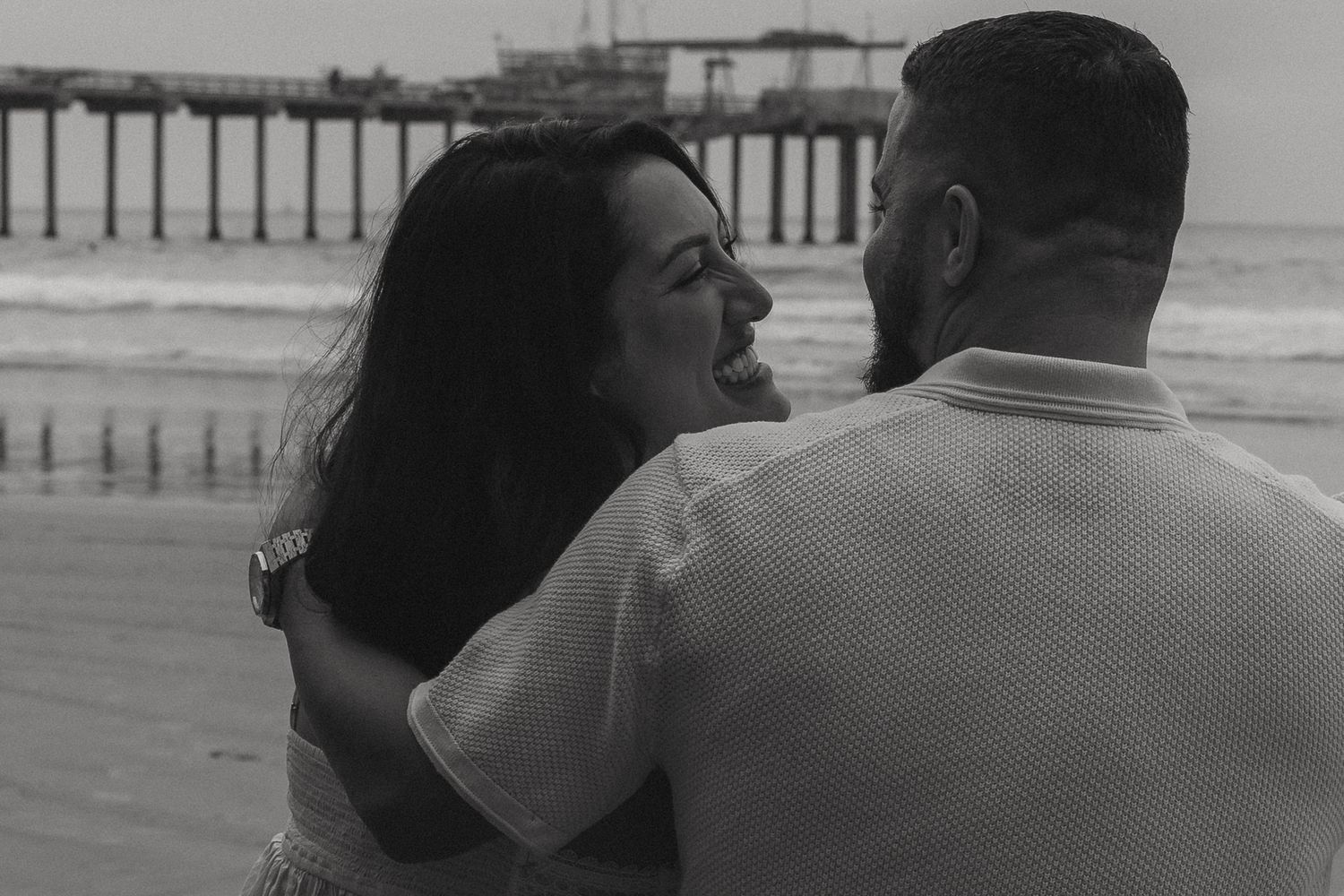 A black and white photo sequence shows a couple in an intimate embrace on the beach.