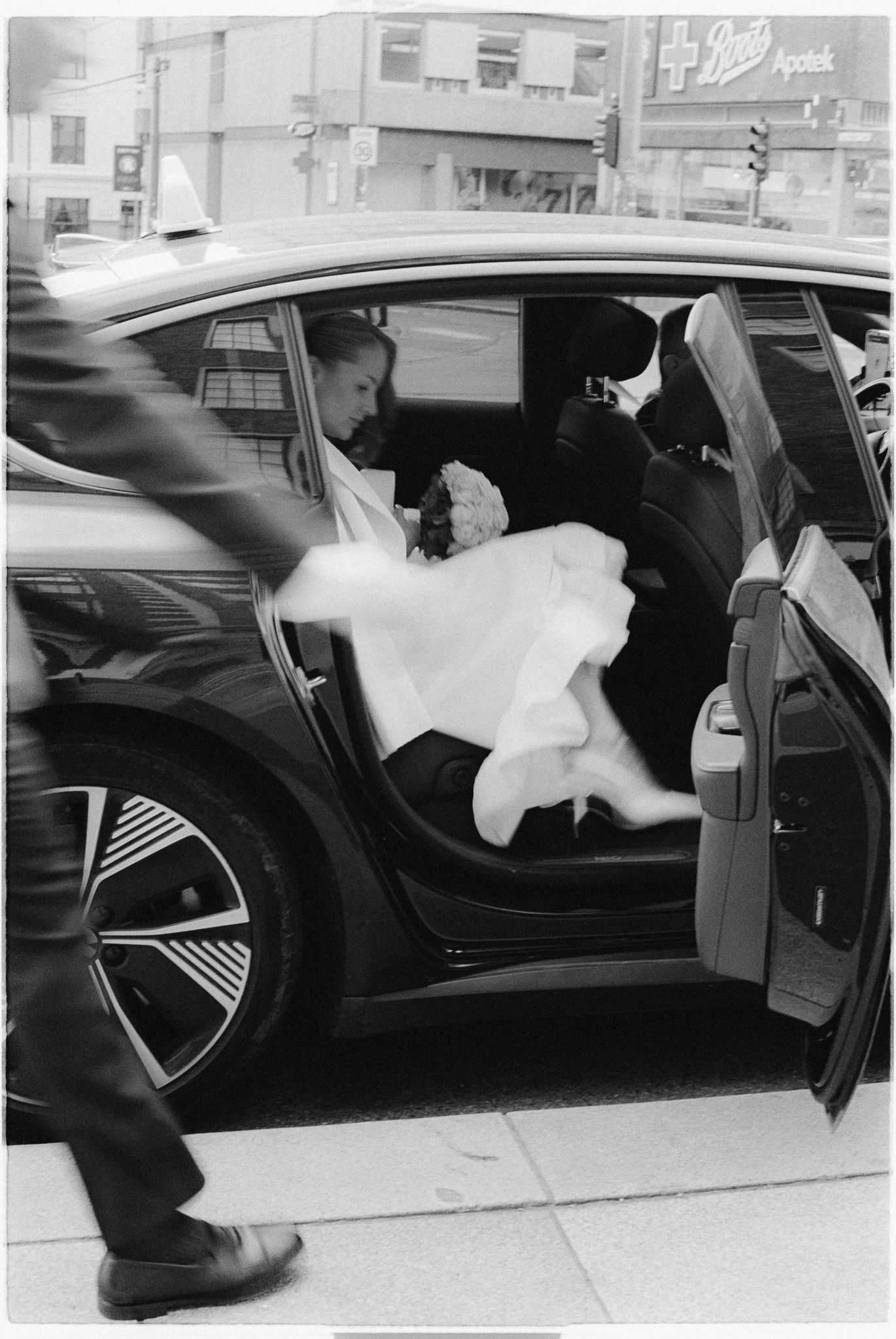 A sequence of black and white photos showing someone in a wedding dress diving into a car through the window.