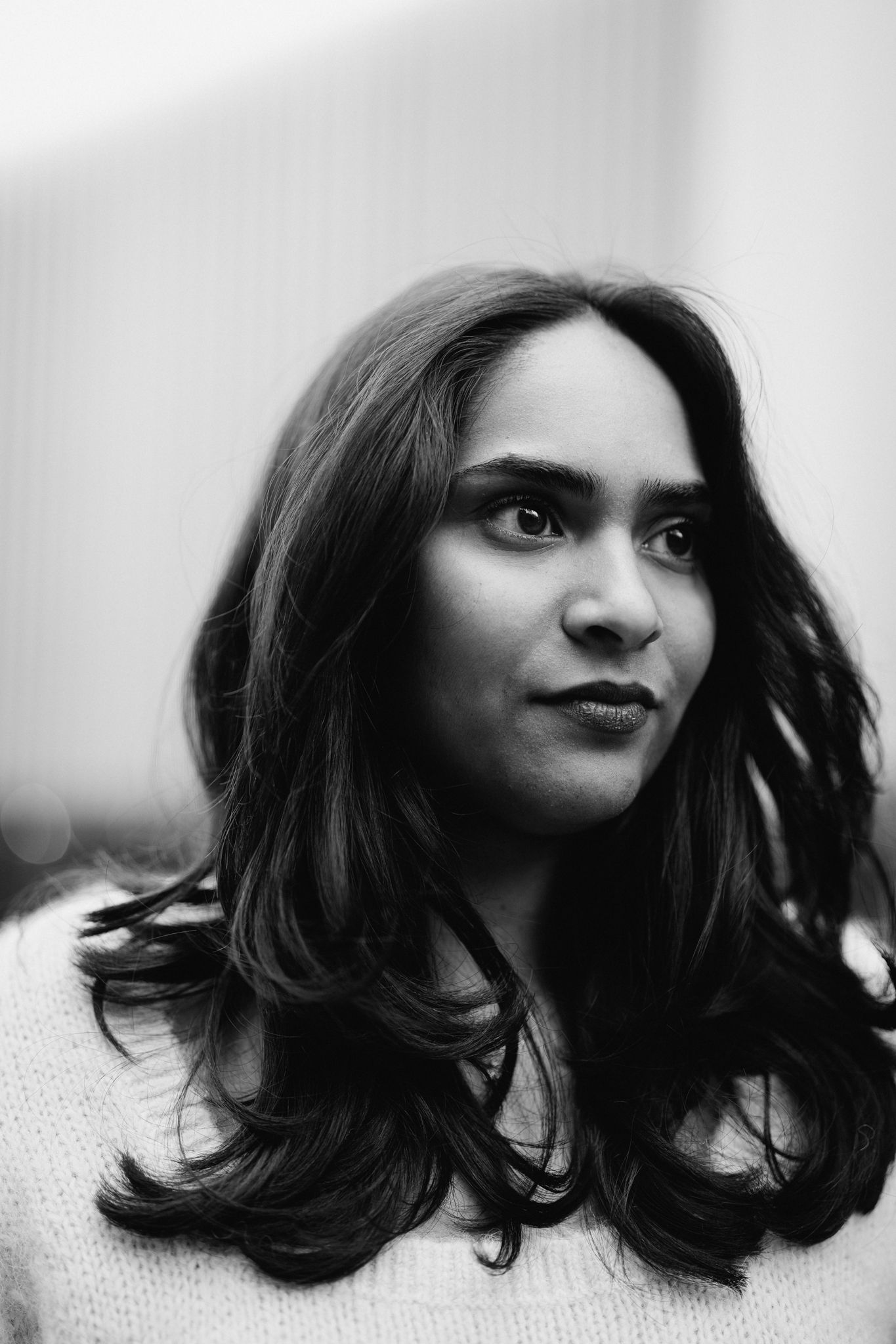 Black and white portrait series showing dark wavy hair and dark lipstick in overcast lighting.
