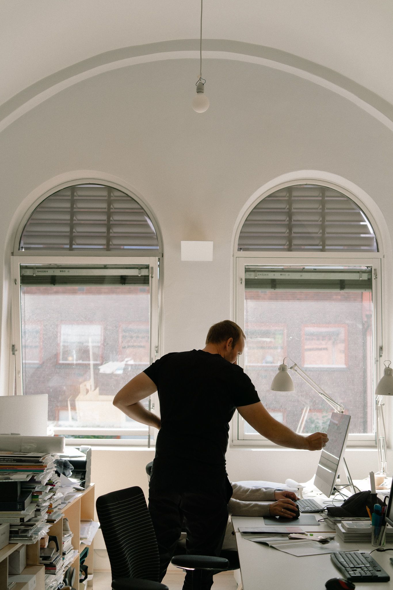 Office space with arched windows and white vaulted ceiling showing a sequence of movement.