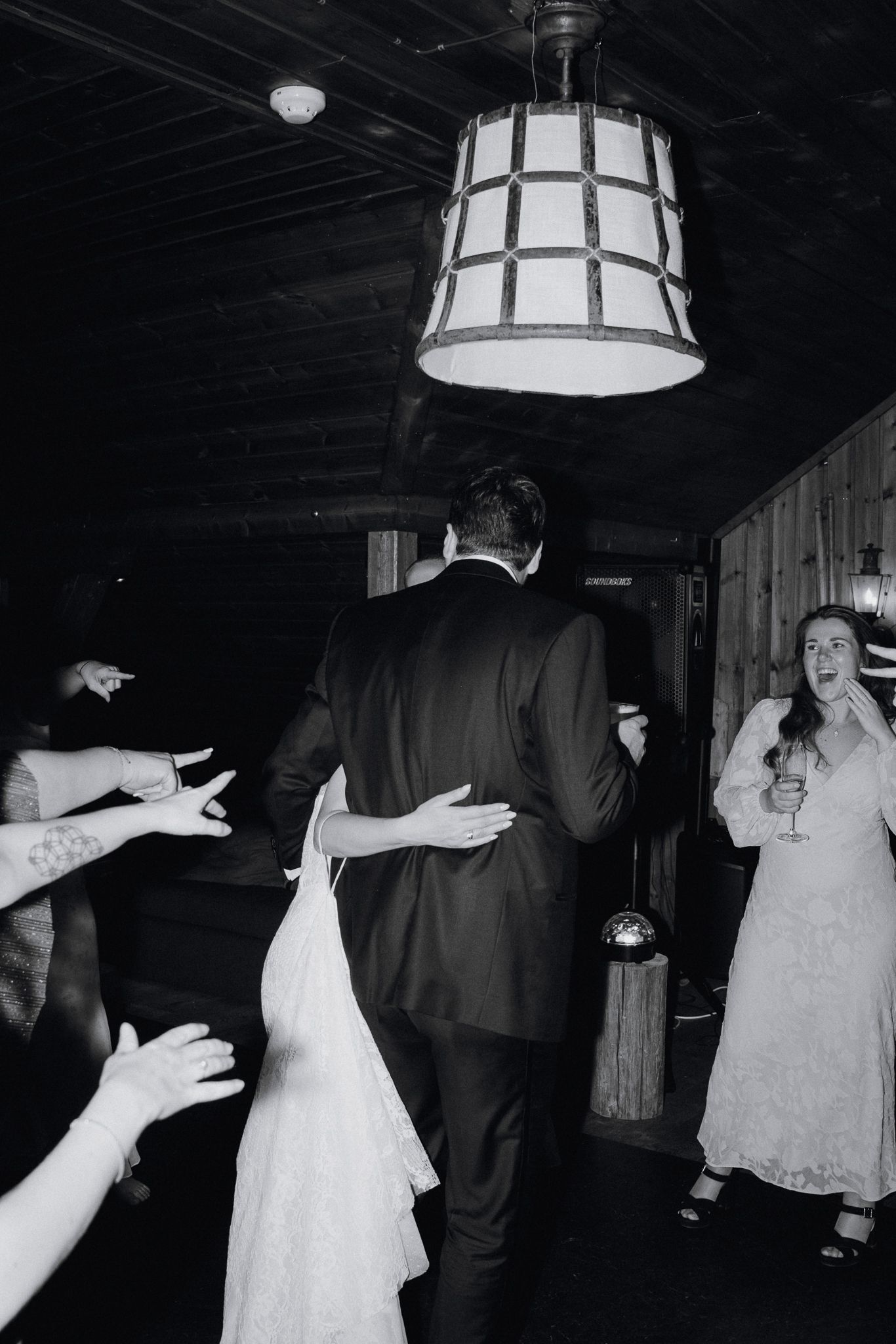 A black and white sequence of dance photos showing couples in formal attire spinning and twirling on a dimly lit dance floor.