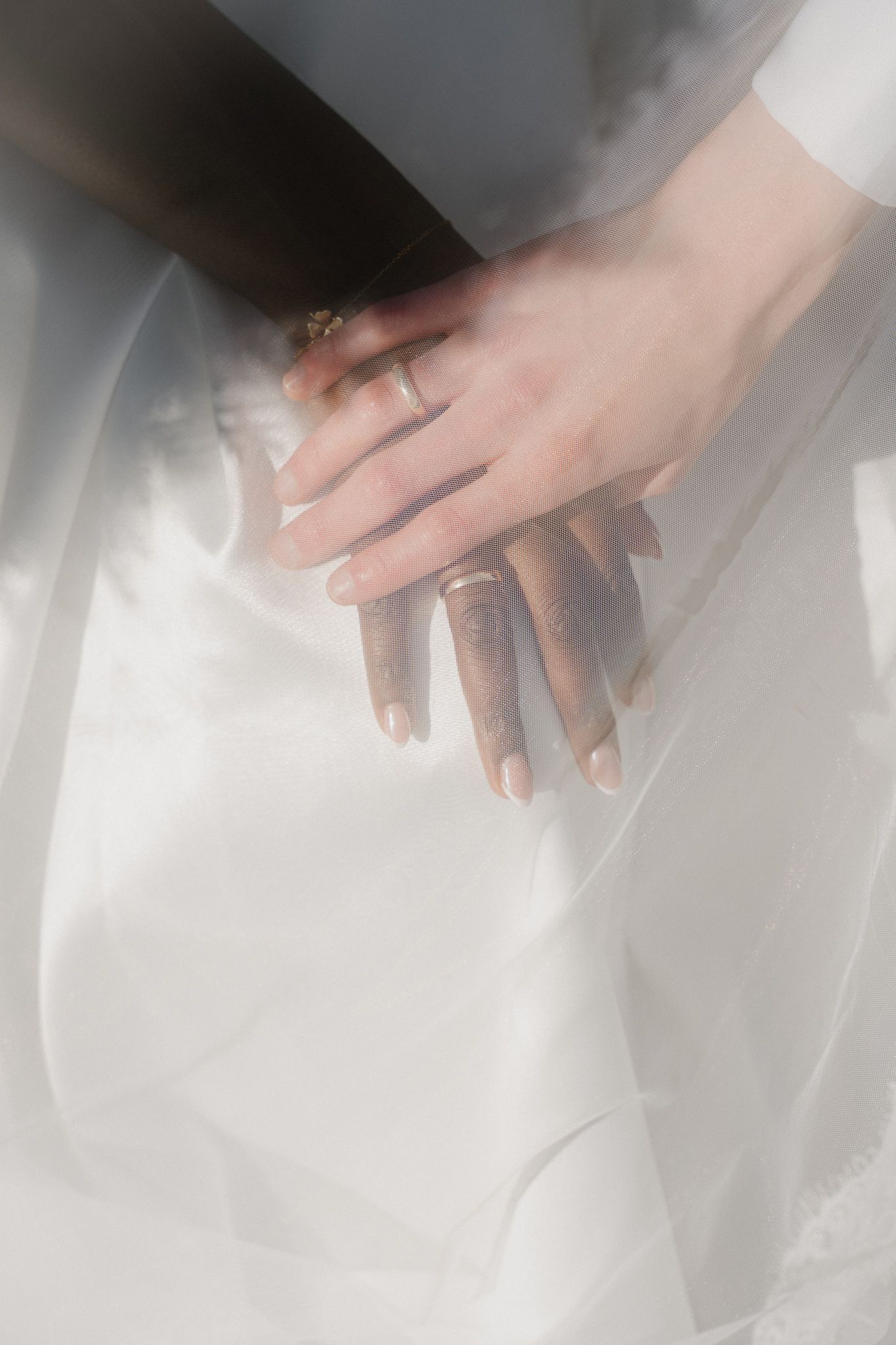 Close-up series of hands delicately pressing down on sheer white fabric creating soft folds and textures.