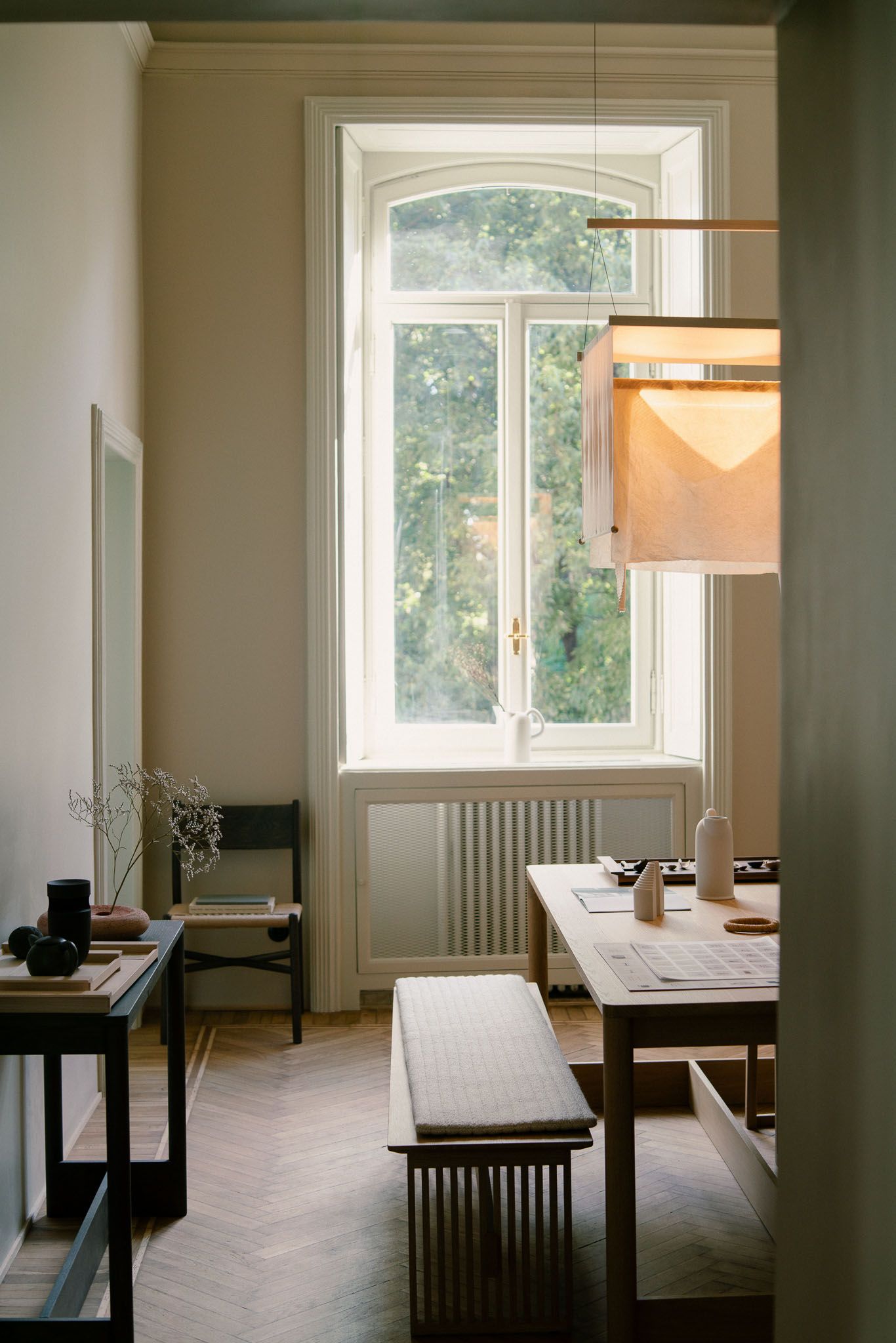 Four connected interior photos showing a minimalist room with white walls, wooden floors, and simple furniture in natural light.