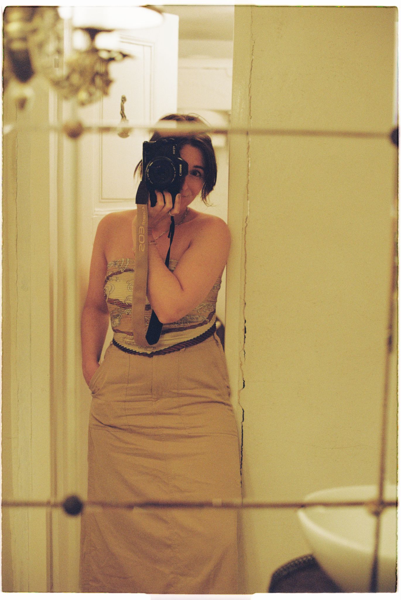 A series of vintage-style sepia photographs showing someone taking pictures in a mirror.