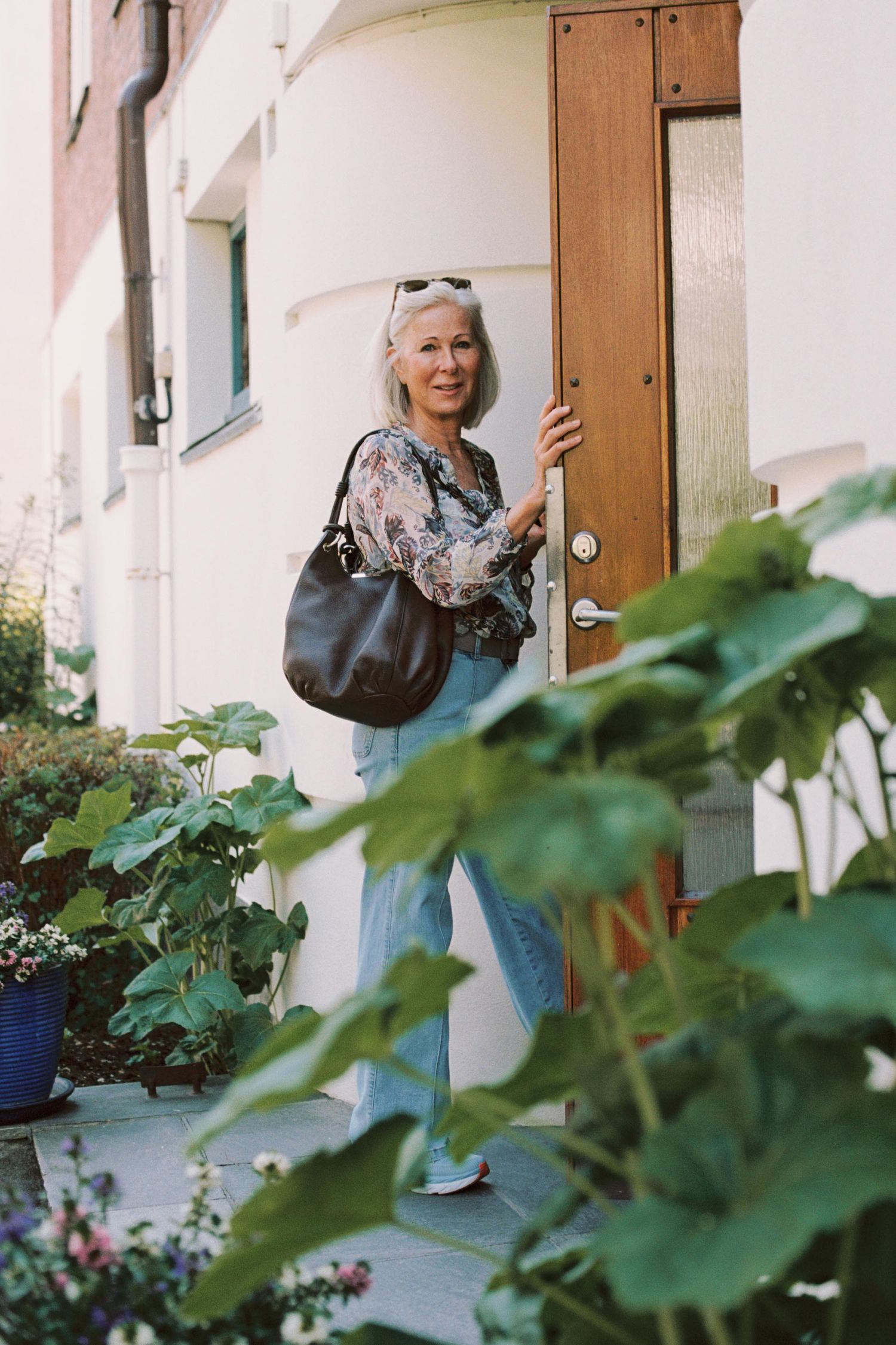 A sequence of photos showing someone entering a doorway next to green foliage and white walls.