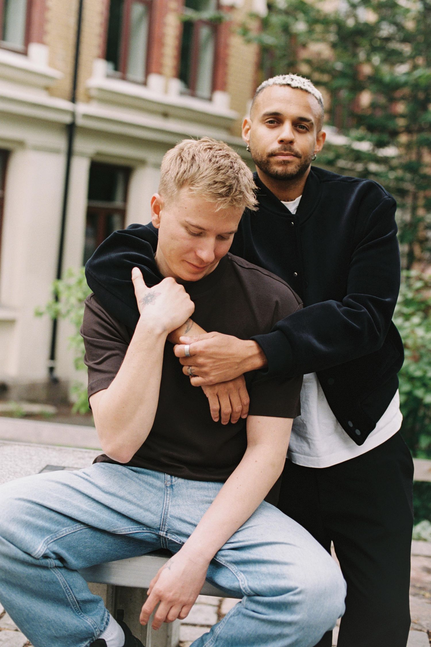 Two people in casual attire sit together outdoors in a series of intimate candid moments.
