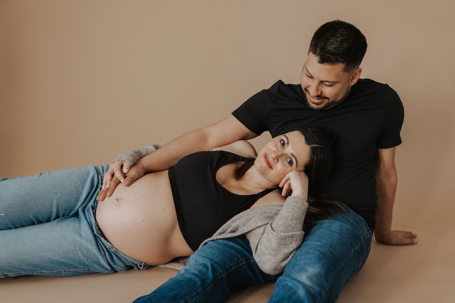 An expecting couple shares a tender moment during a maternity photoshoot.