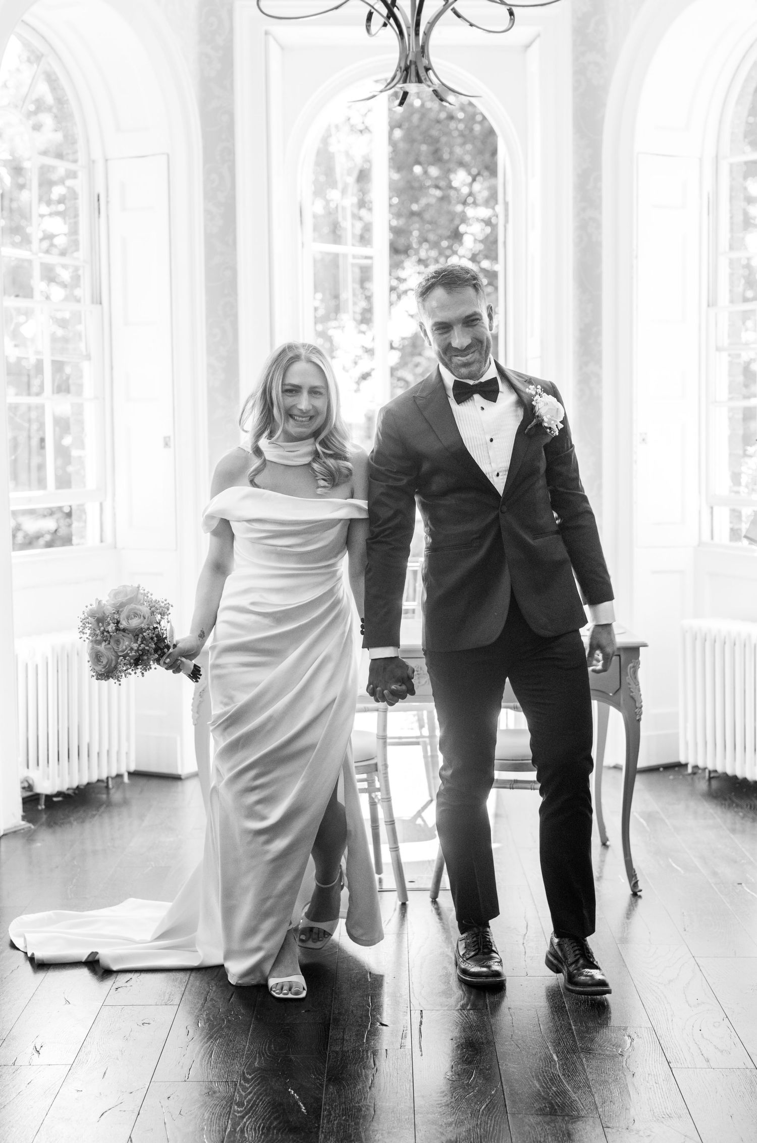 Black and white photo series showing a couple dancing and laughing together on a wooden floor at their wedding celebration.
