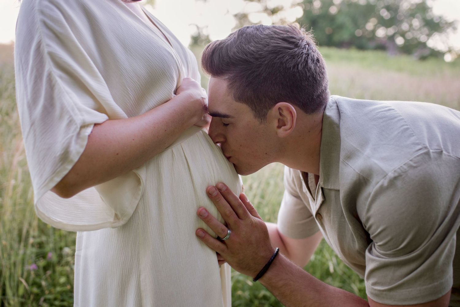 Tender moment captured in a sunlit meadow with tall grass.