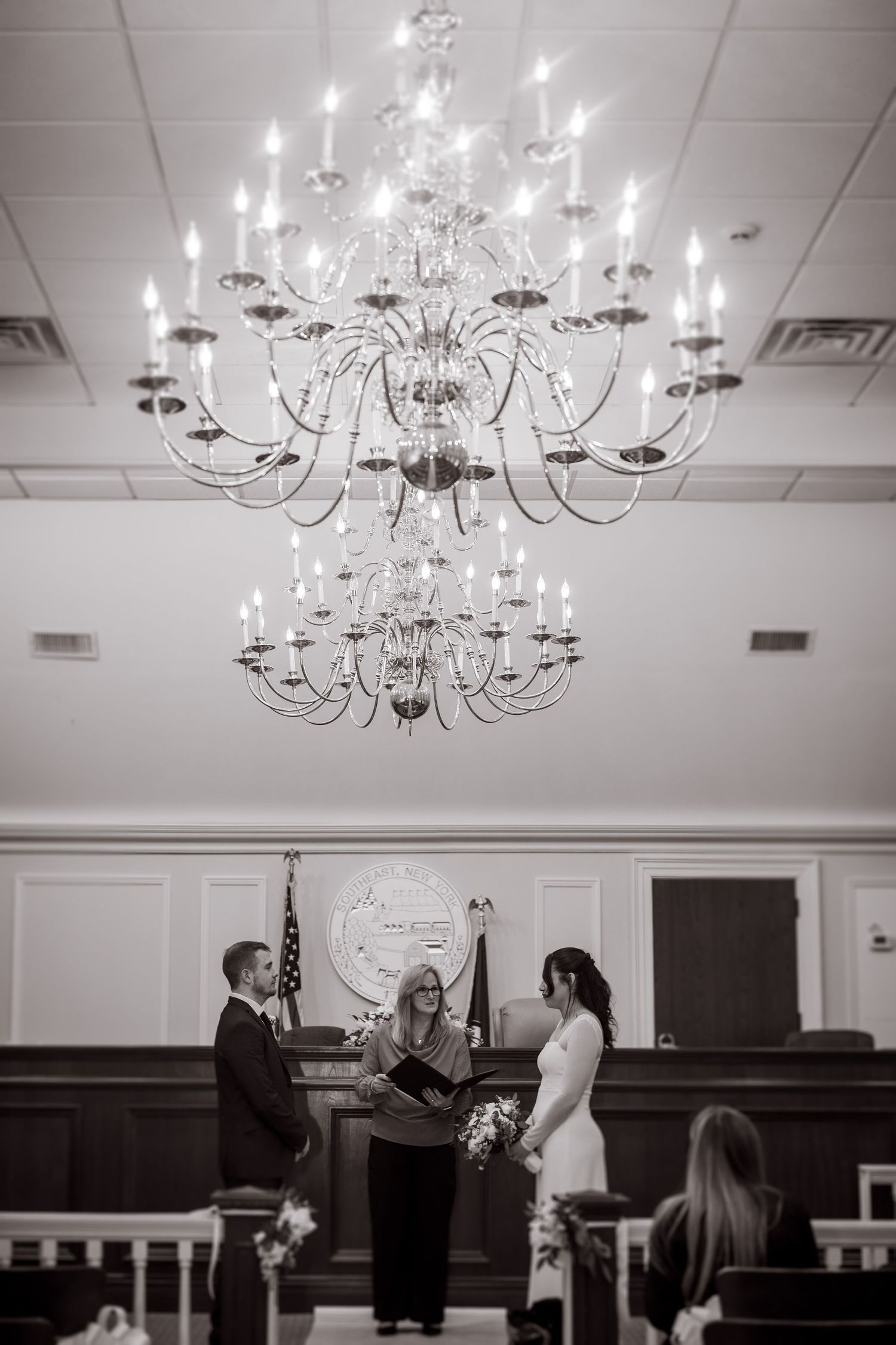 Elegant crystal chandelier hanging in a formal ceremony space.