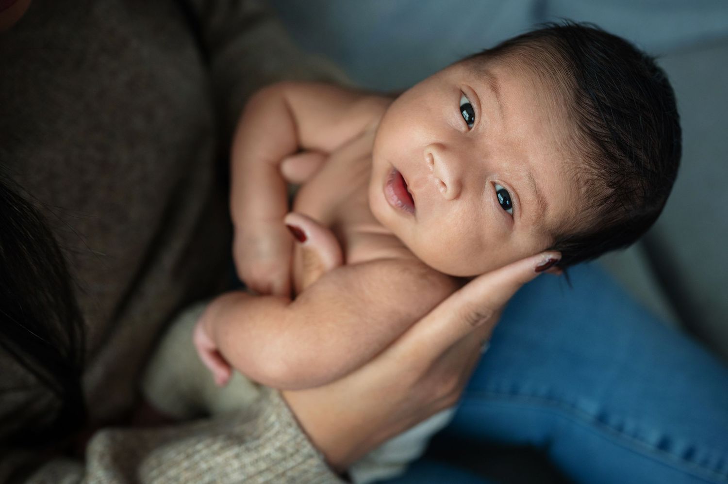 Artistic portrait series showing tender family interactions in moody blue lighting.