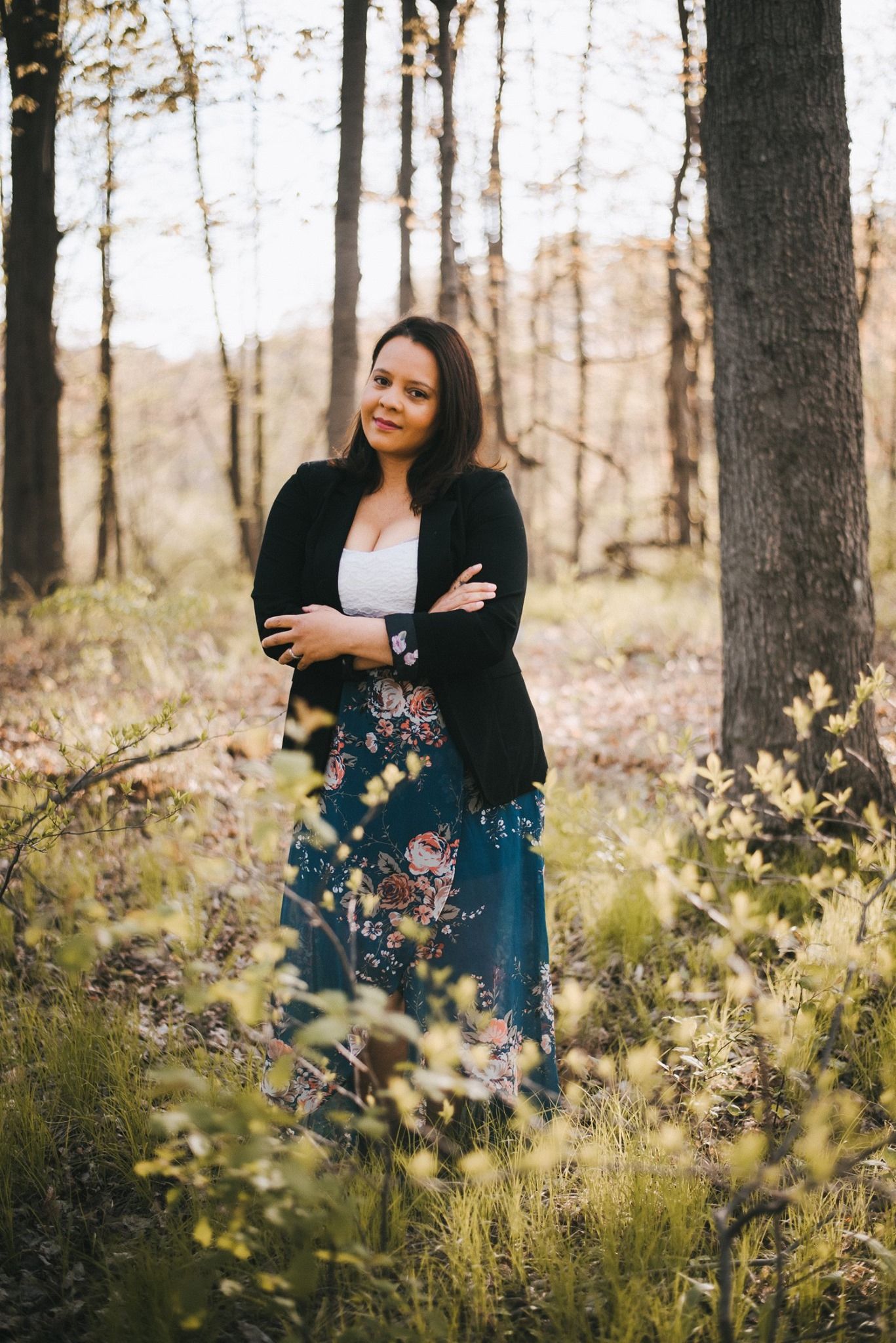 Portrait session in wooded area with soft natural lighting filtering through trees.