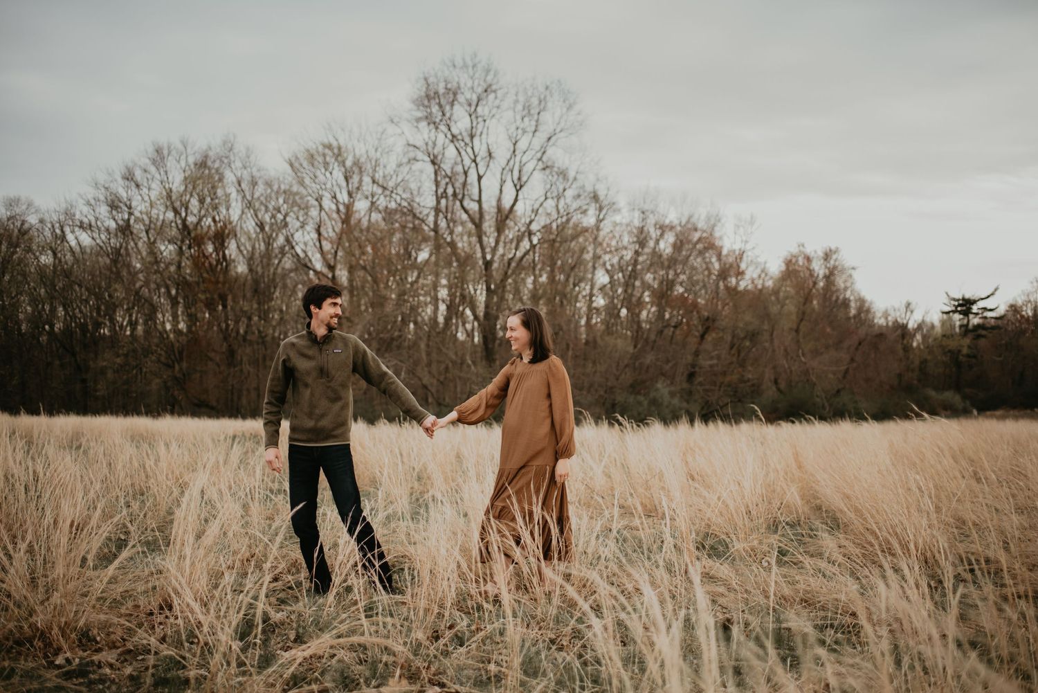 Scenic autumn field photoshoot with tall grass and overcast sky.