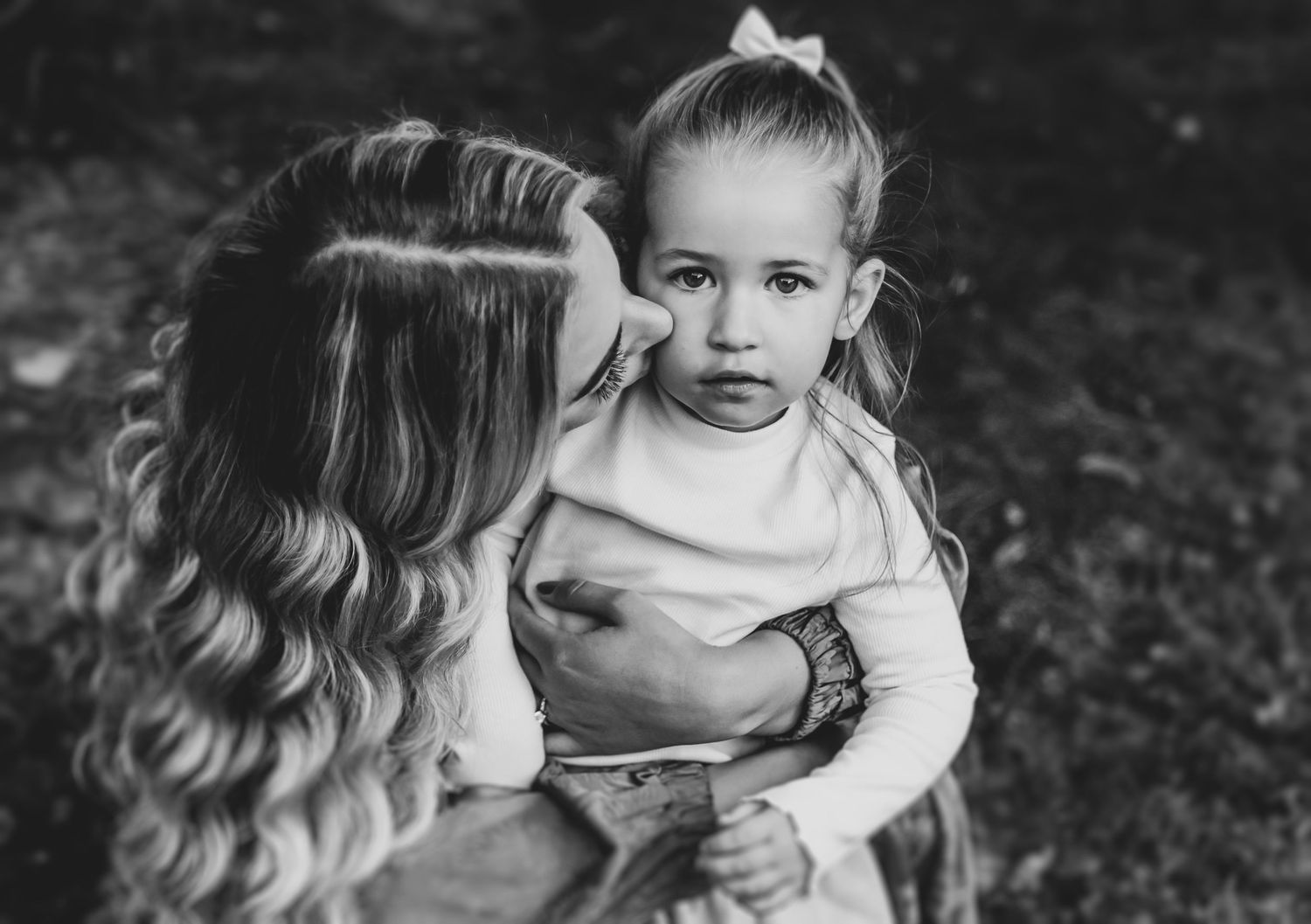 Black and white collage of tender moments between mother and child in an outdoor setting.