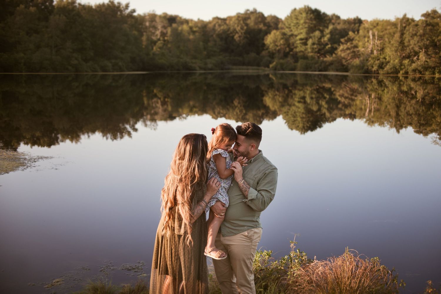 Romantic lakeside photoshoot during golden hour with nature reflections.