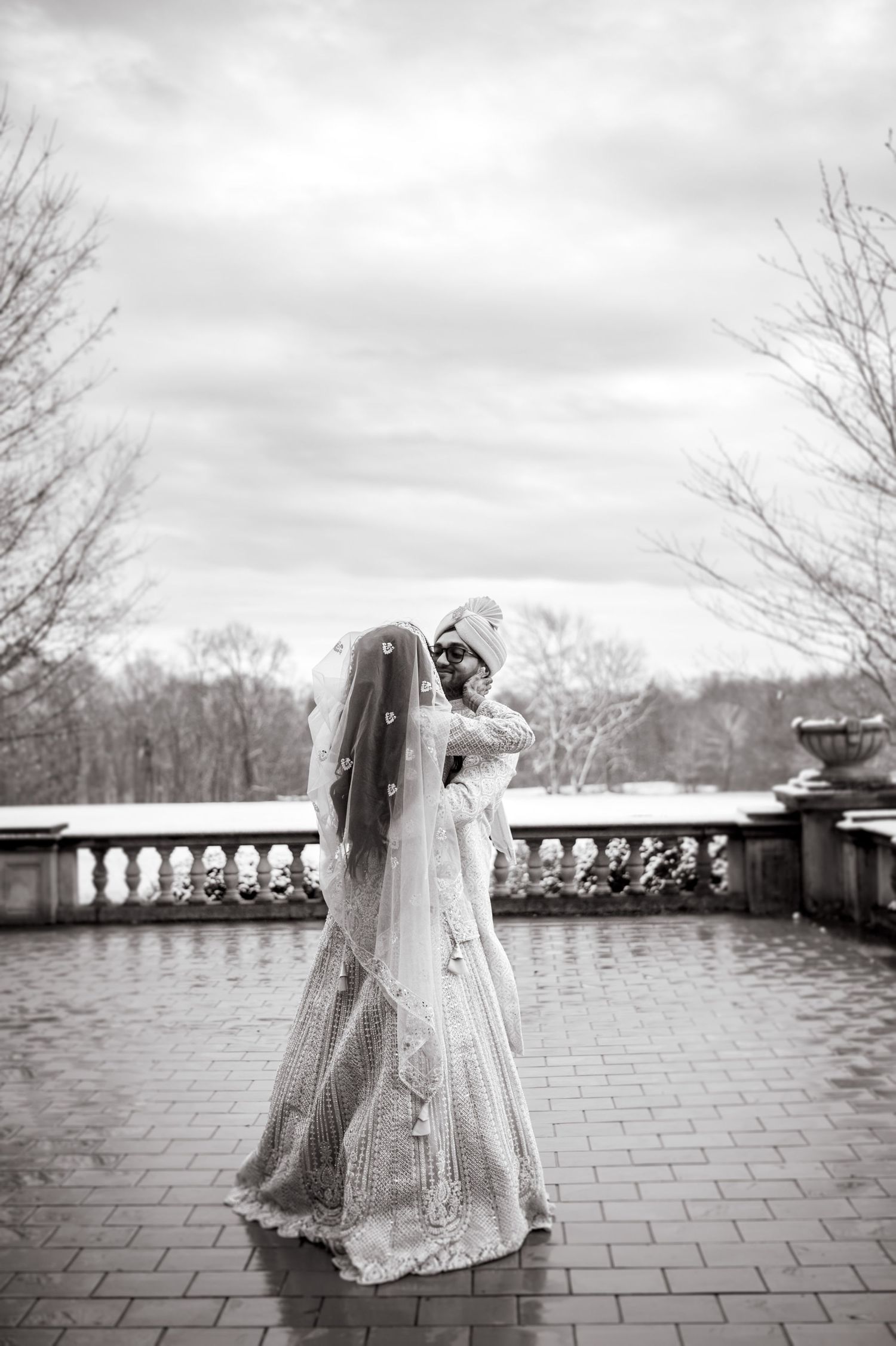 Dancing together on a stone patio in elegant white attire.