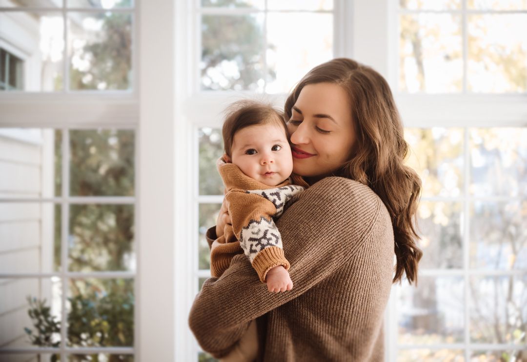 A cozy indoor portrait session with warm natural light streaming through windows.