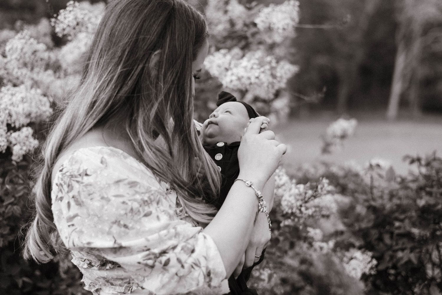 A black and white photo series showing someone in a garden surrounded by blooming cherry blossoms.