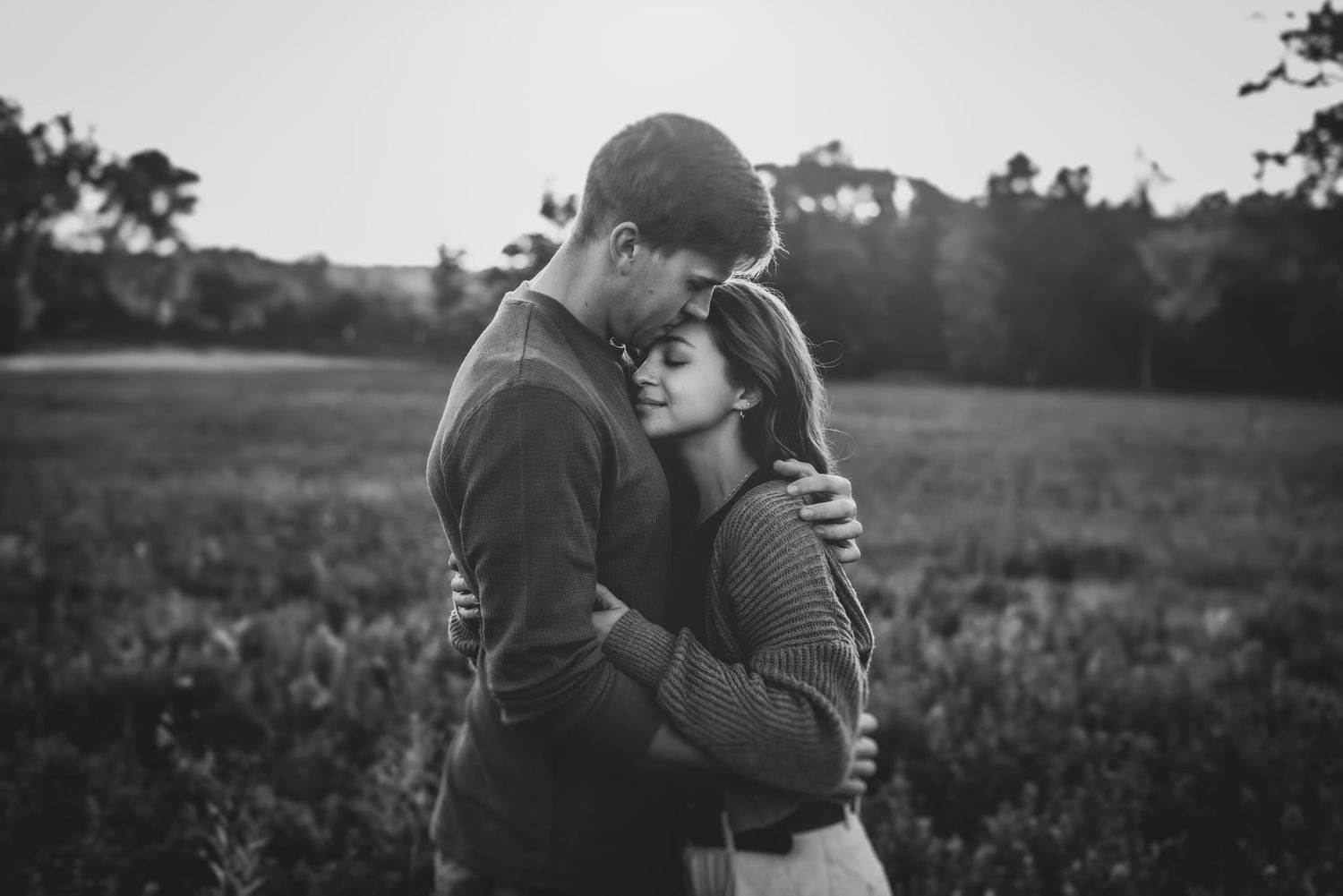 Black and white portraits of couple in rustic field setting.