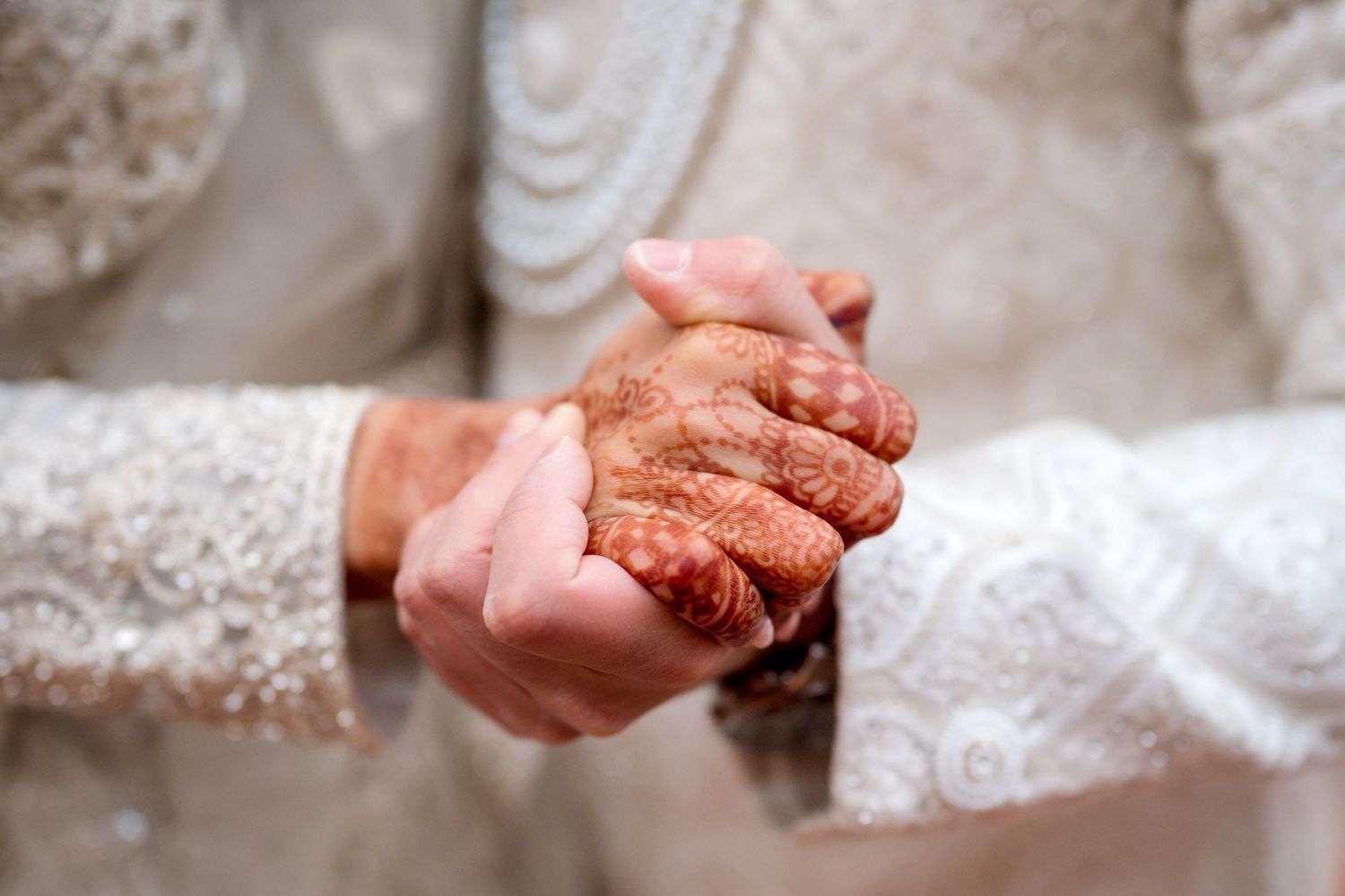 Close-up of hands with intricate henna designs.