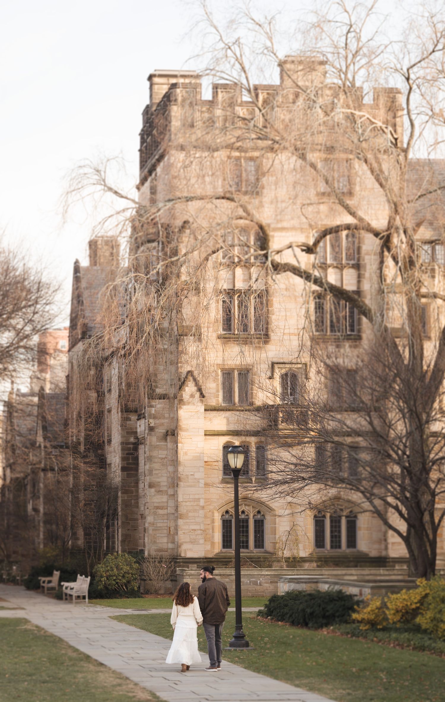 Gothic stone building with bare trees against an overcast sky.