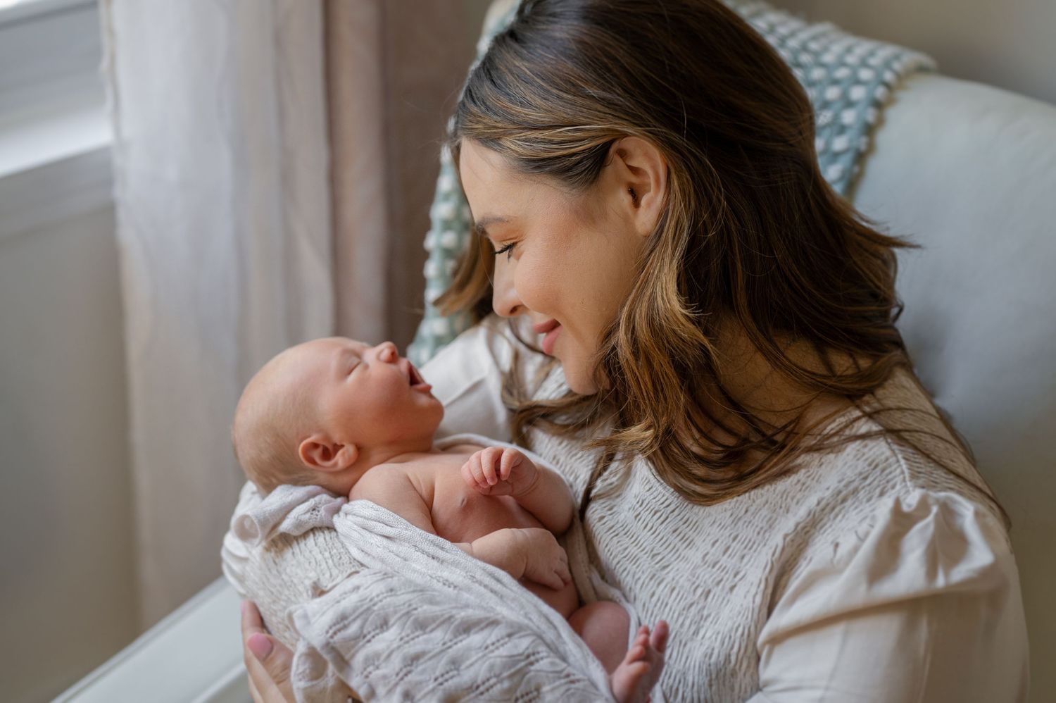A tender newborn photography session showing intimate moments between parent and baby in soft lighting.