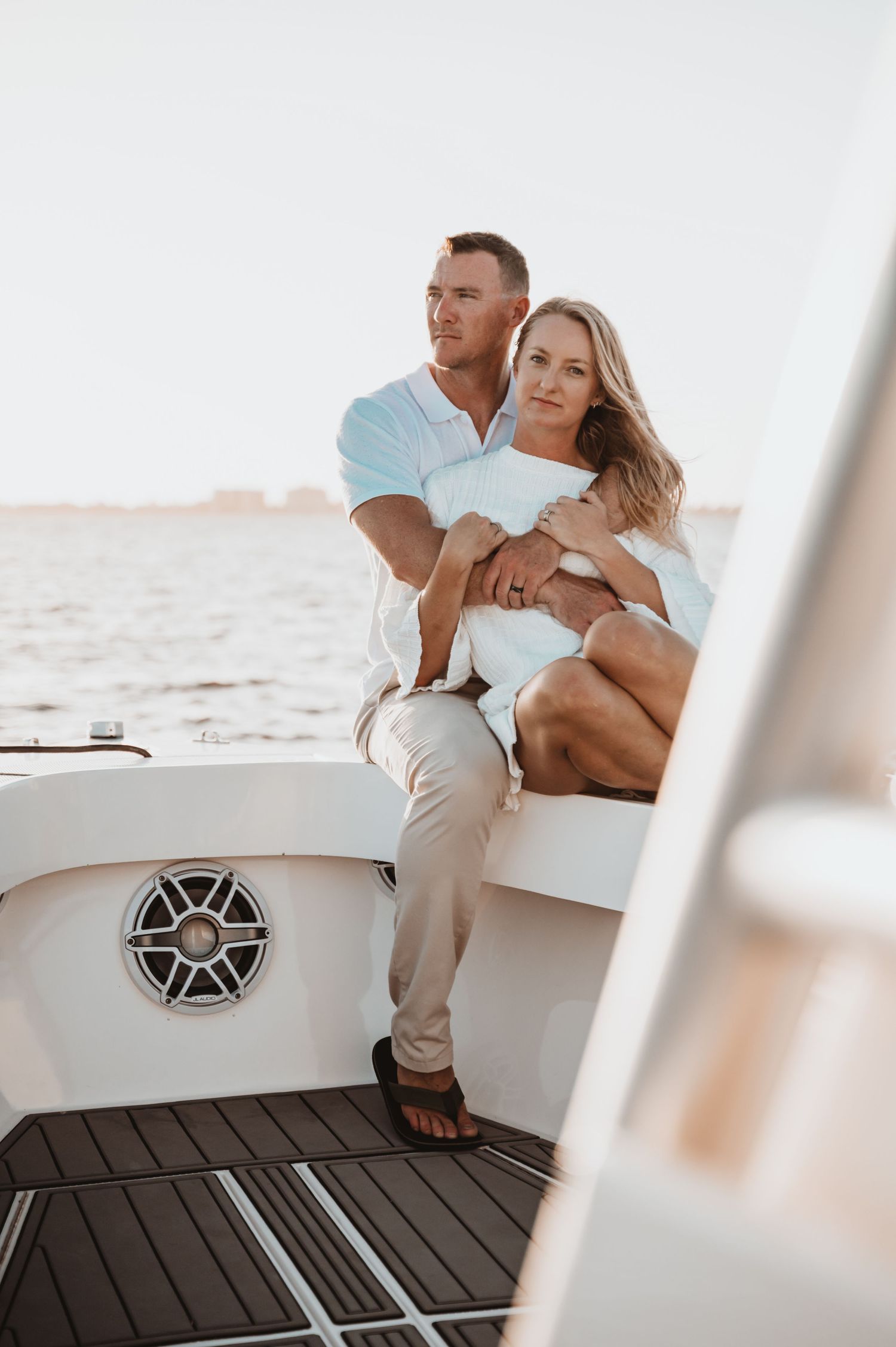 Romantic couple relaxing together on a luxury white boat deck during sunset.