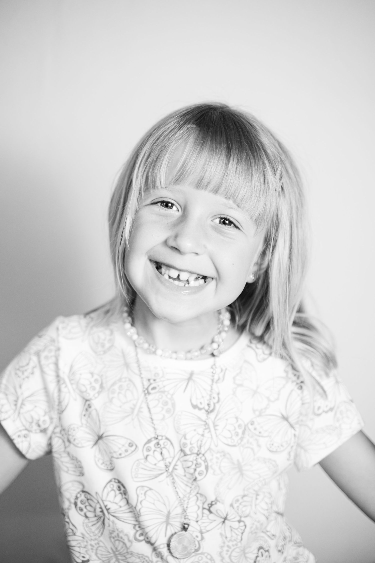 Black and white portrait series capturing joyful expressions in a white patterned shirt.