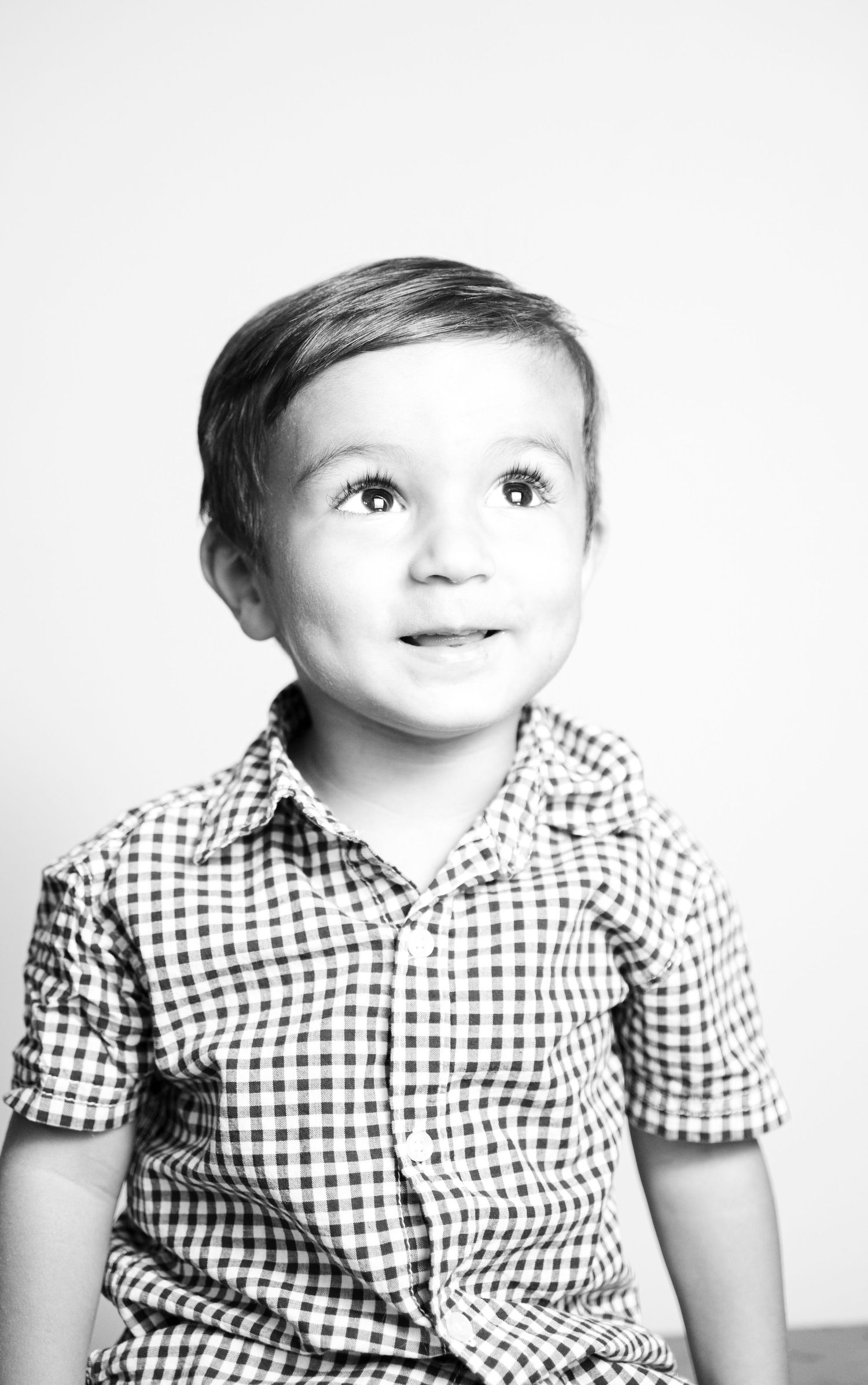 Black and white portrait series showing various expressions in a checkered shirt.