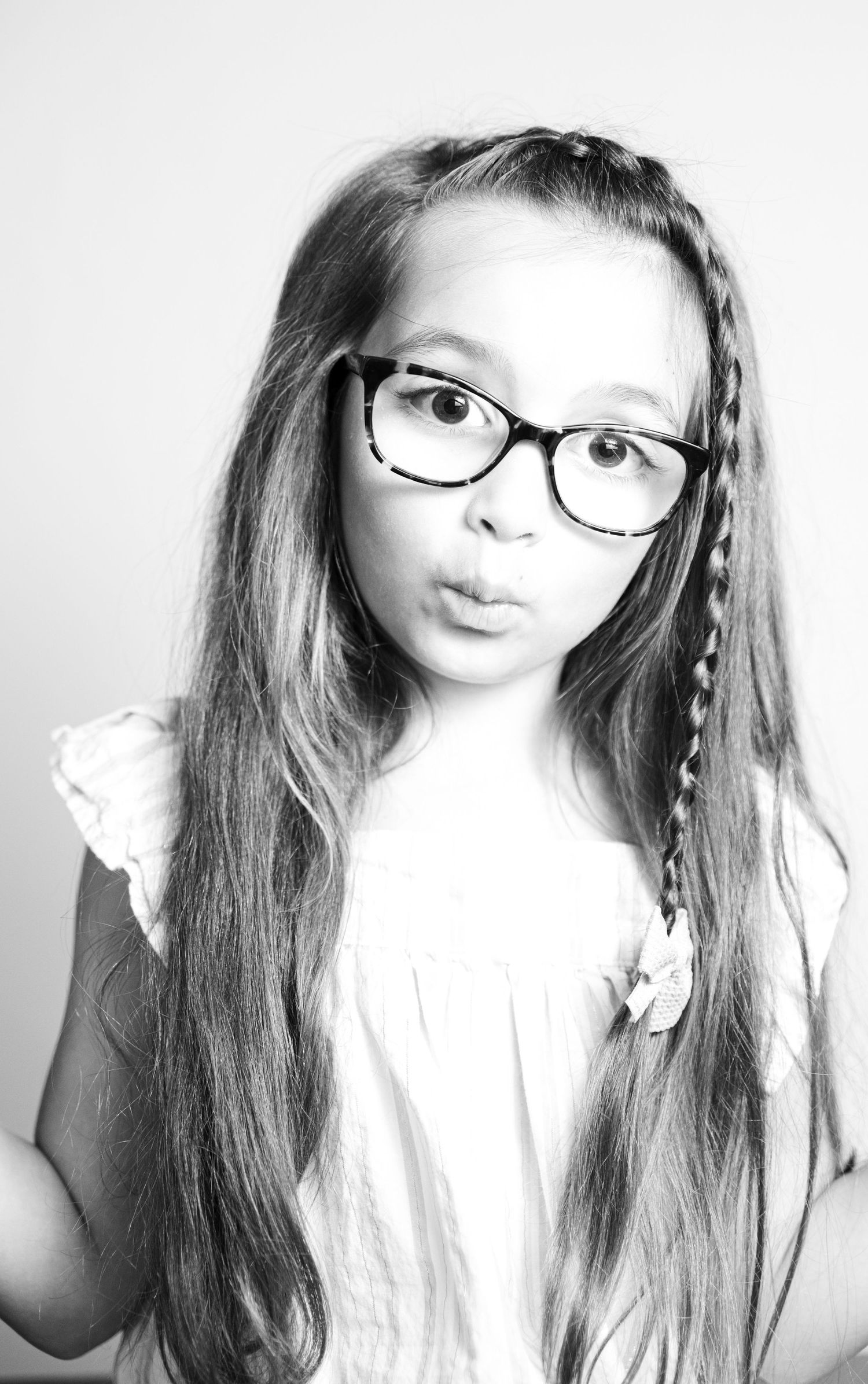 Black and white portrait series featuring playful poses and expressions while wearing glasses.