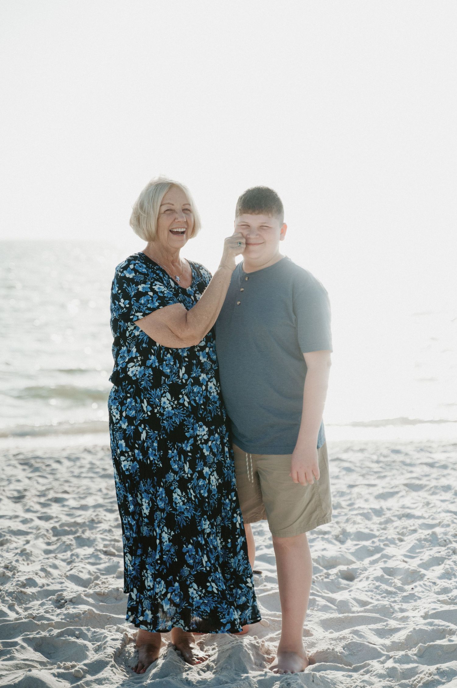 Family members sharing a joyful moment together on a sunny beach.