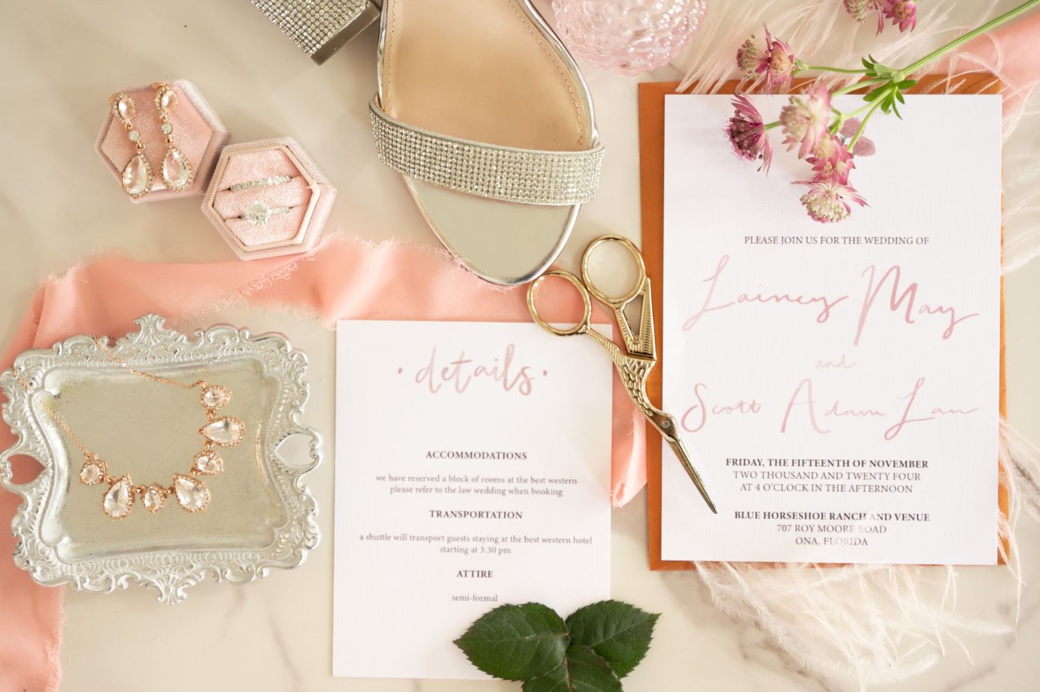 Pink and white wedding invitations with floral designs and elegant calligraphy.