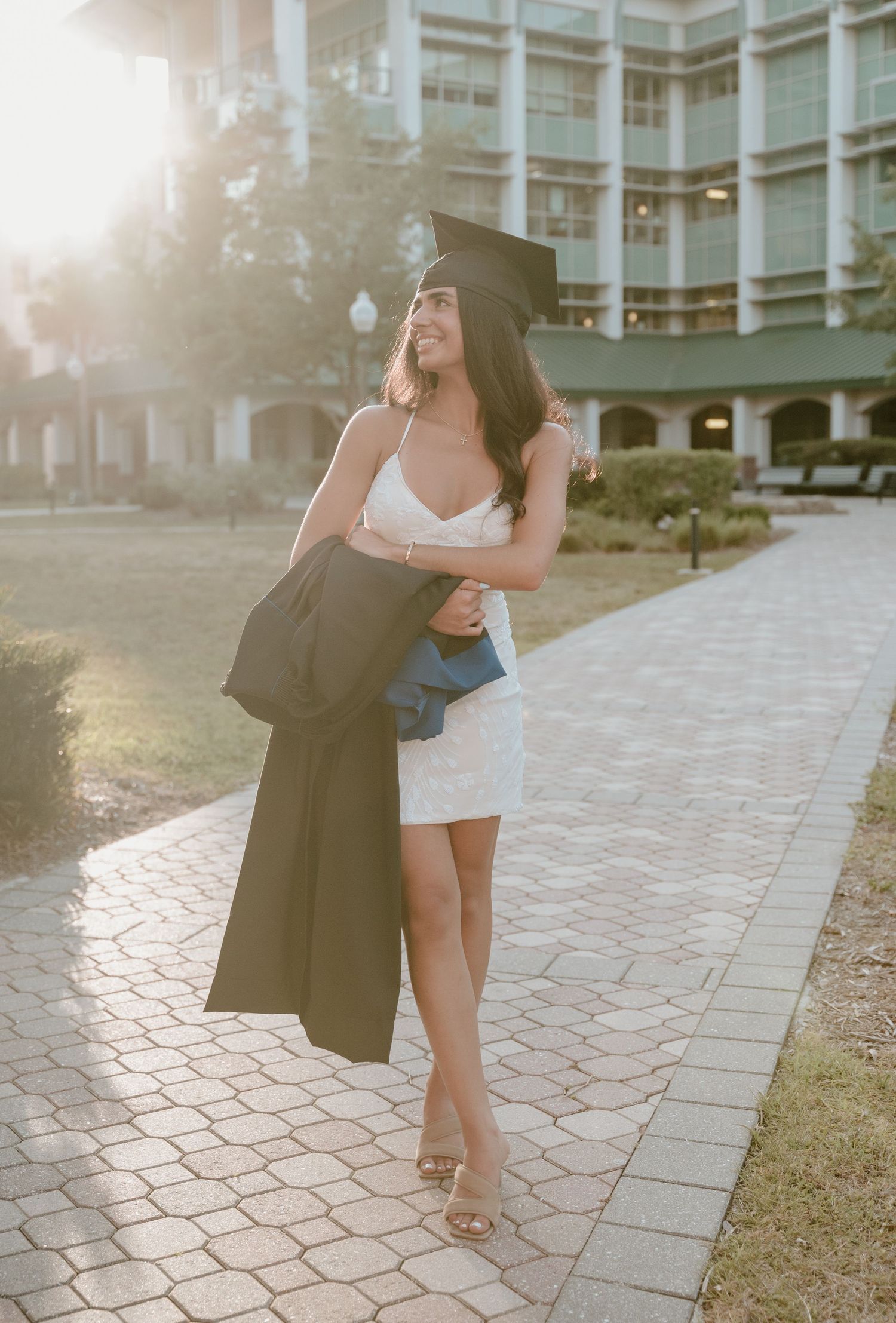 Graduation photoshoot featuring celebratory poses outside contemporary architecture.