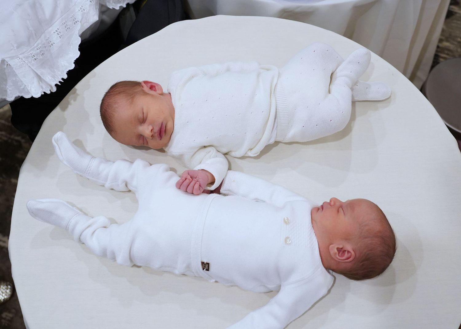 Newborn twins holding hands