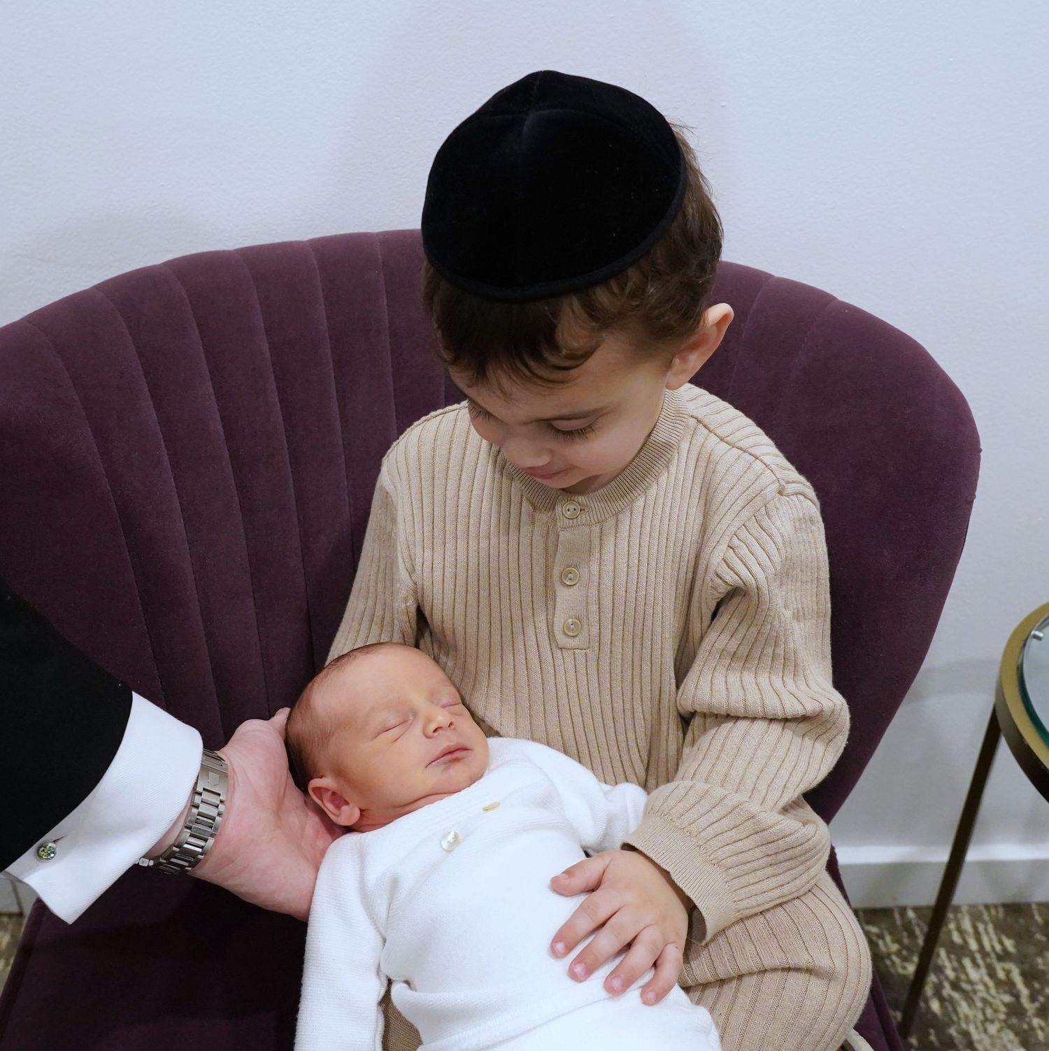 Oldest brother holding one of his new baby brothers